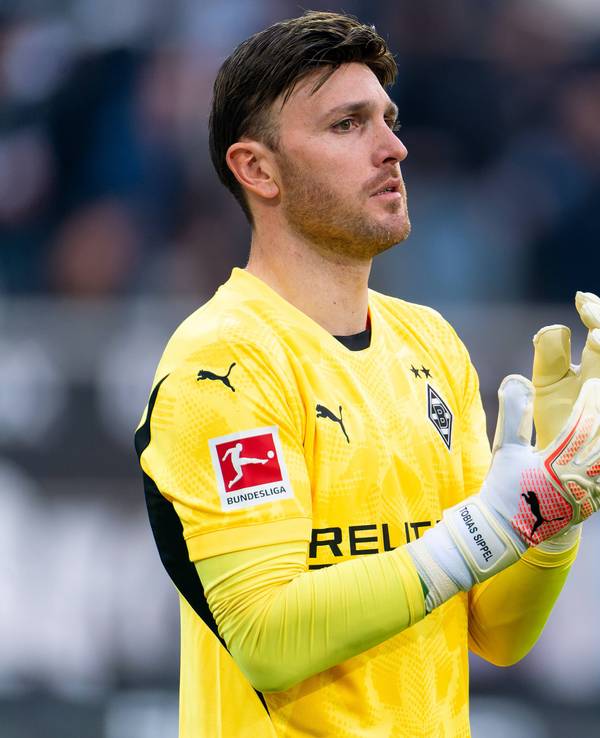 Borussia Mönchengladbachs Torwart Tobias Sippel steht im Bundesliga-Spiel gegen den FC Augsburg im Tor und richtet sich die Handschuhe.