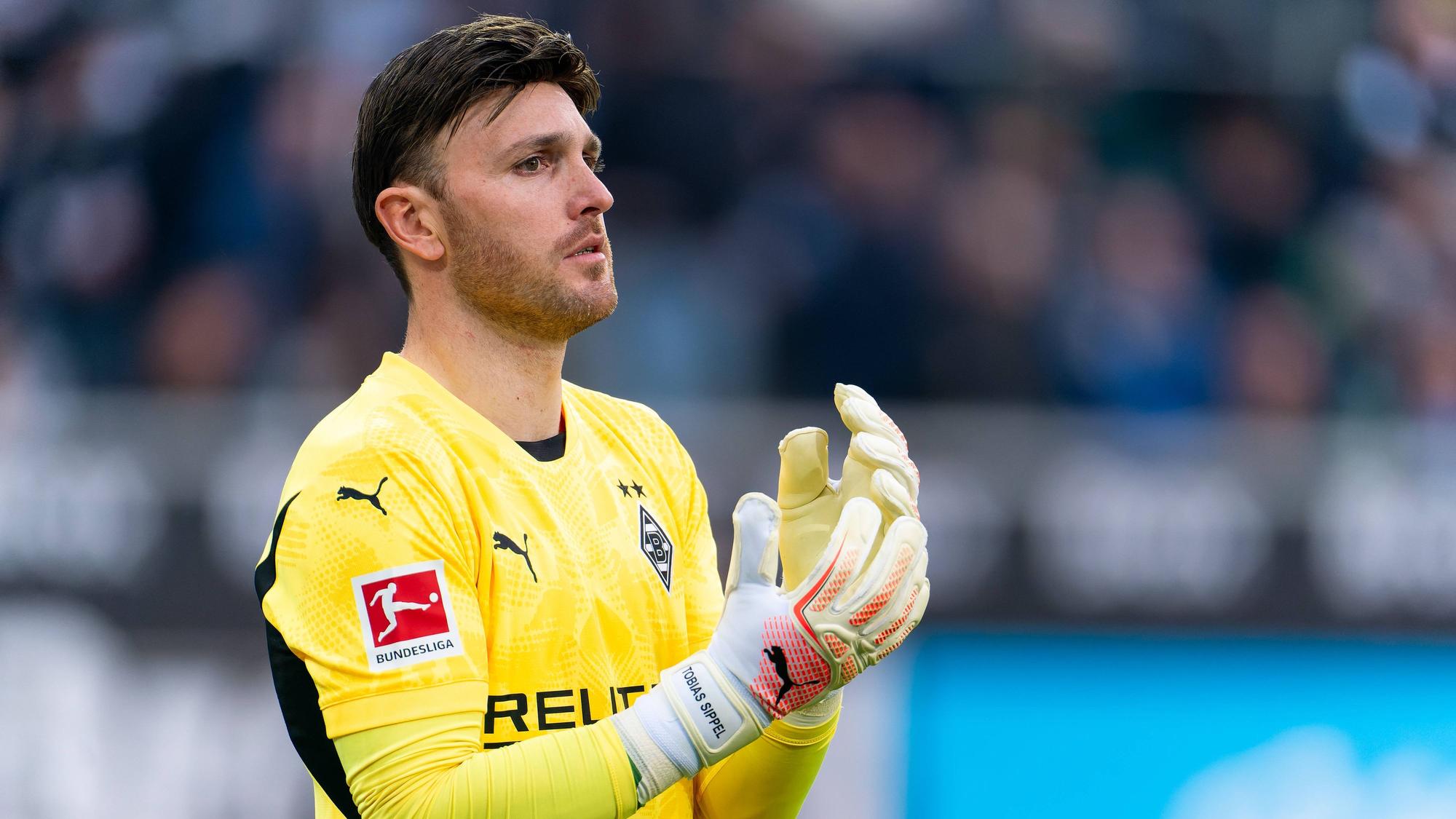 Borussia Mönchengladbachs Torwart Tobias Sippel steht im Bundesliga-Spiel gegen den FC Augsburg im Tor und richtet sich die Handschuhe.