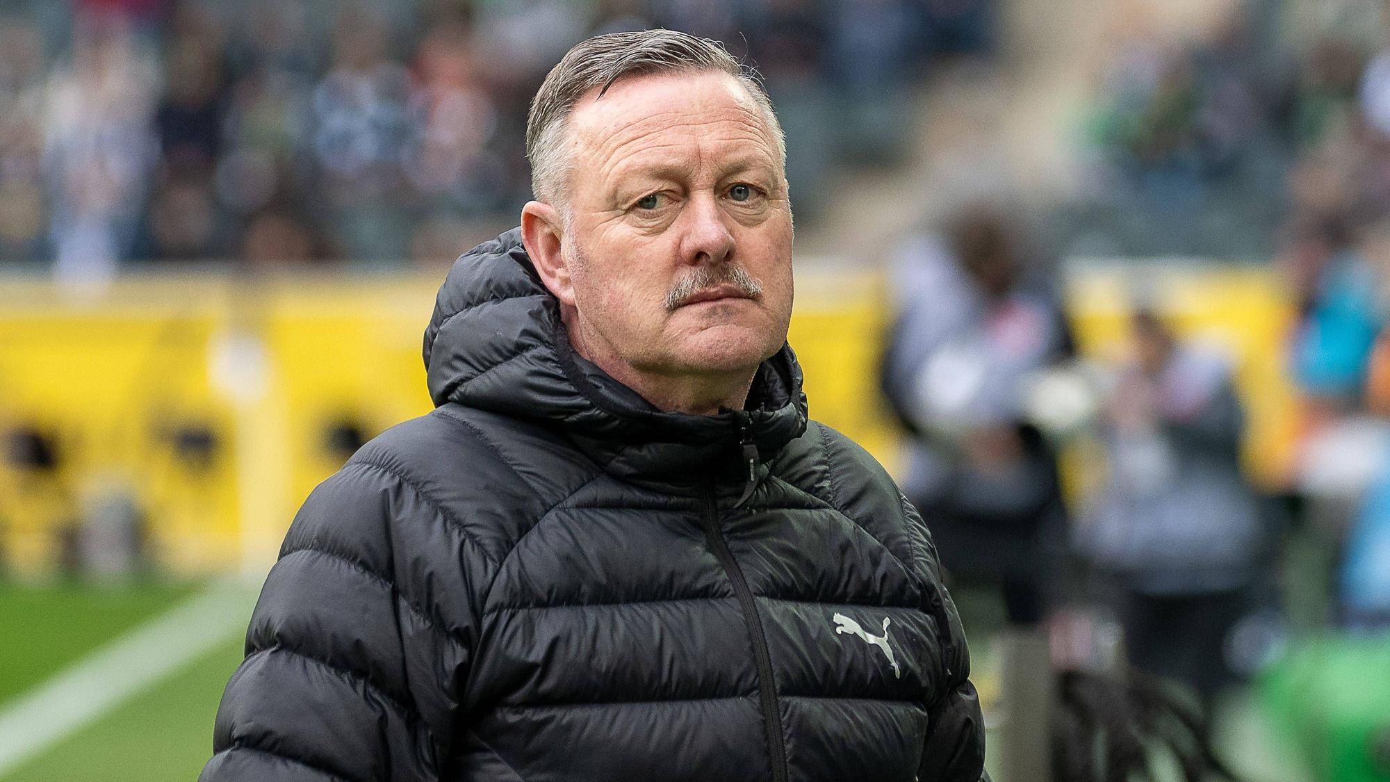 Borussia Mönchengladbachs Sport-Geschäftsführer Roland Virkus steht beim Bundesliga-Spiel gegen den FC Augsburg mit ernstem Blick am Spielfeldrand.