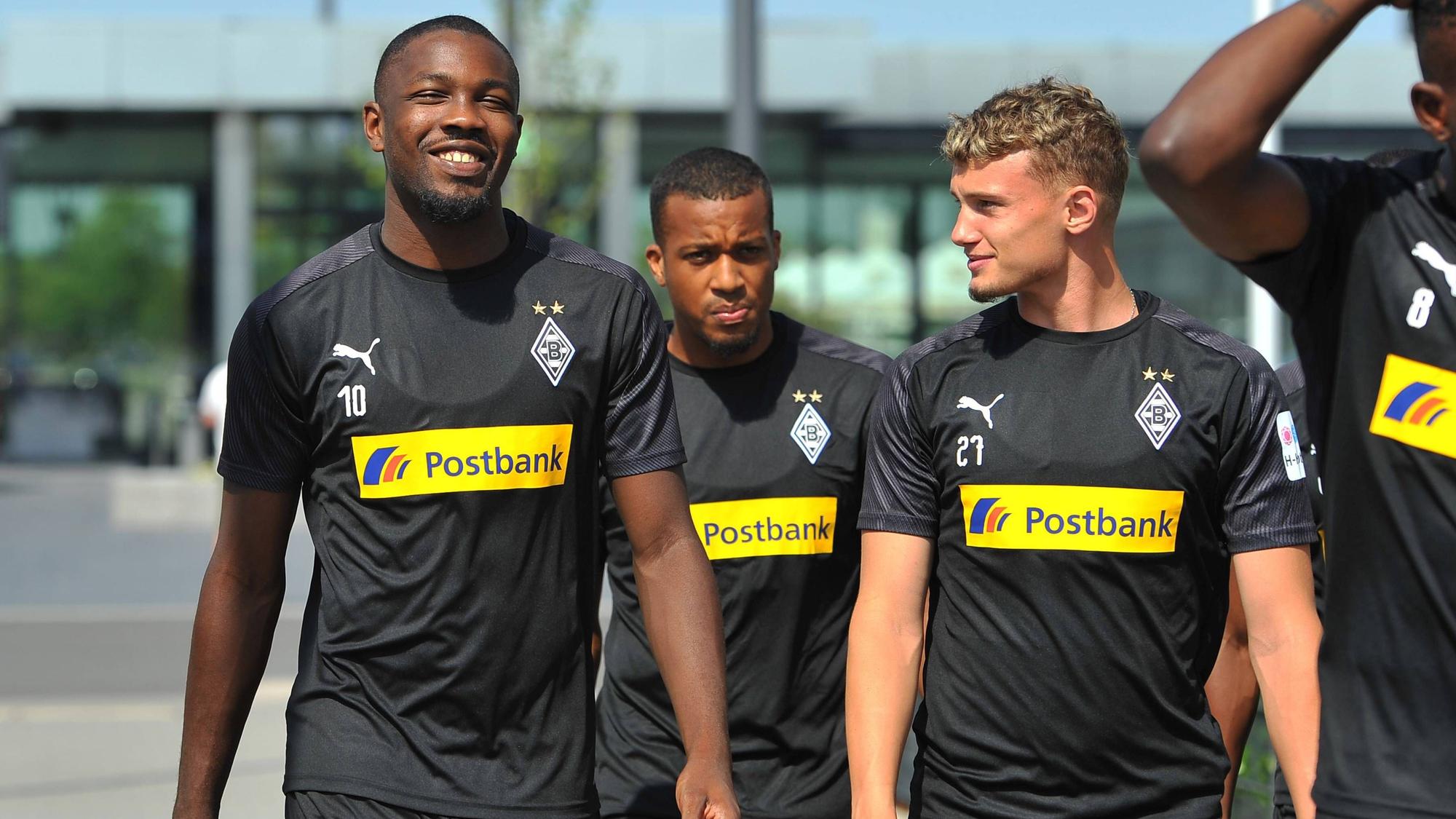 Die Gladbacher gehen am Borussia-Park in der Sonne zum Trainingsplatz.