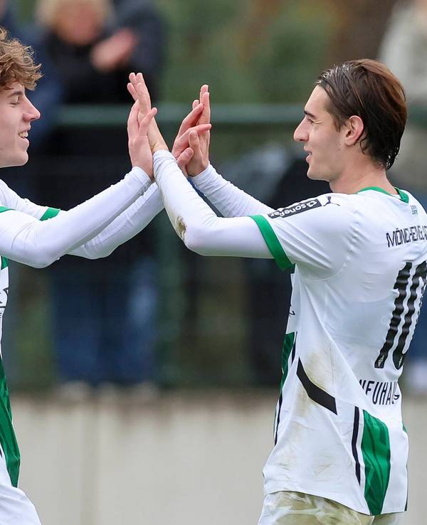 Angreifer Yannick Michaelis und Mittelfeldspieler Florian Neuhaus klatschen sich im Spiel ihres Klubs Borussia Mönchengladbach gegen Preußen Münster ab.