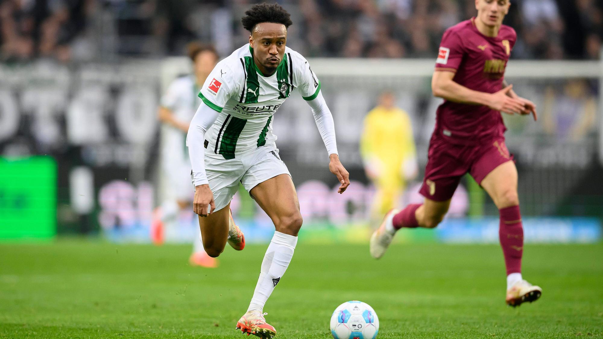 Nathan Ngoumou rennt mit dem Ball auf dem Platz.