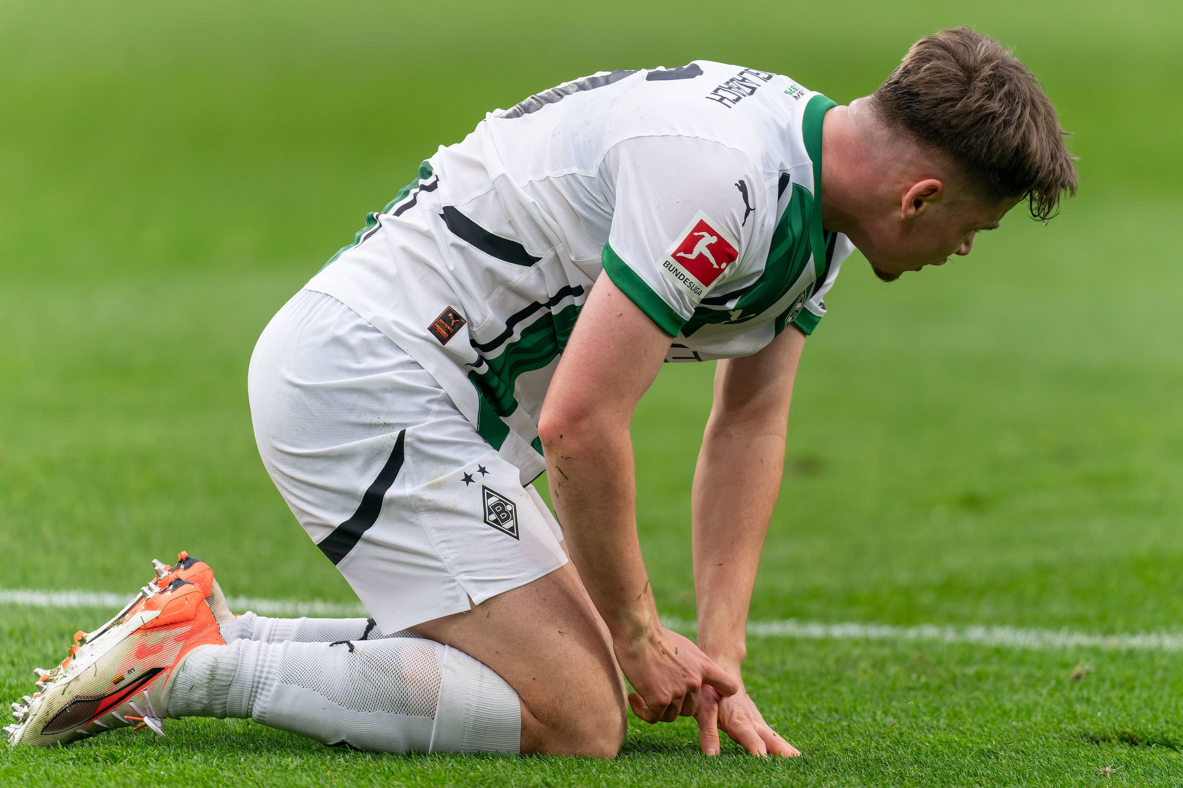 Borussia Mönchengladbachs Lukas Ullrich kniet im Bundesliga-Heimspiel gegen den FC Augsburg auf dem Platz.