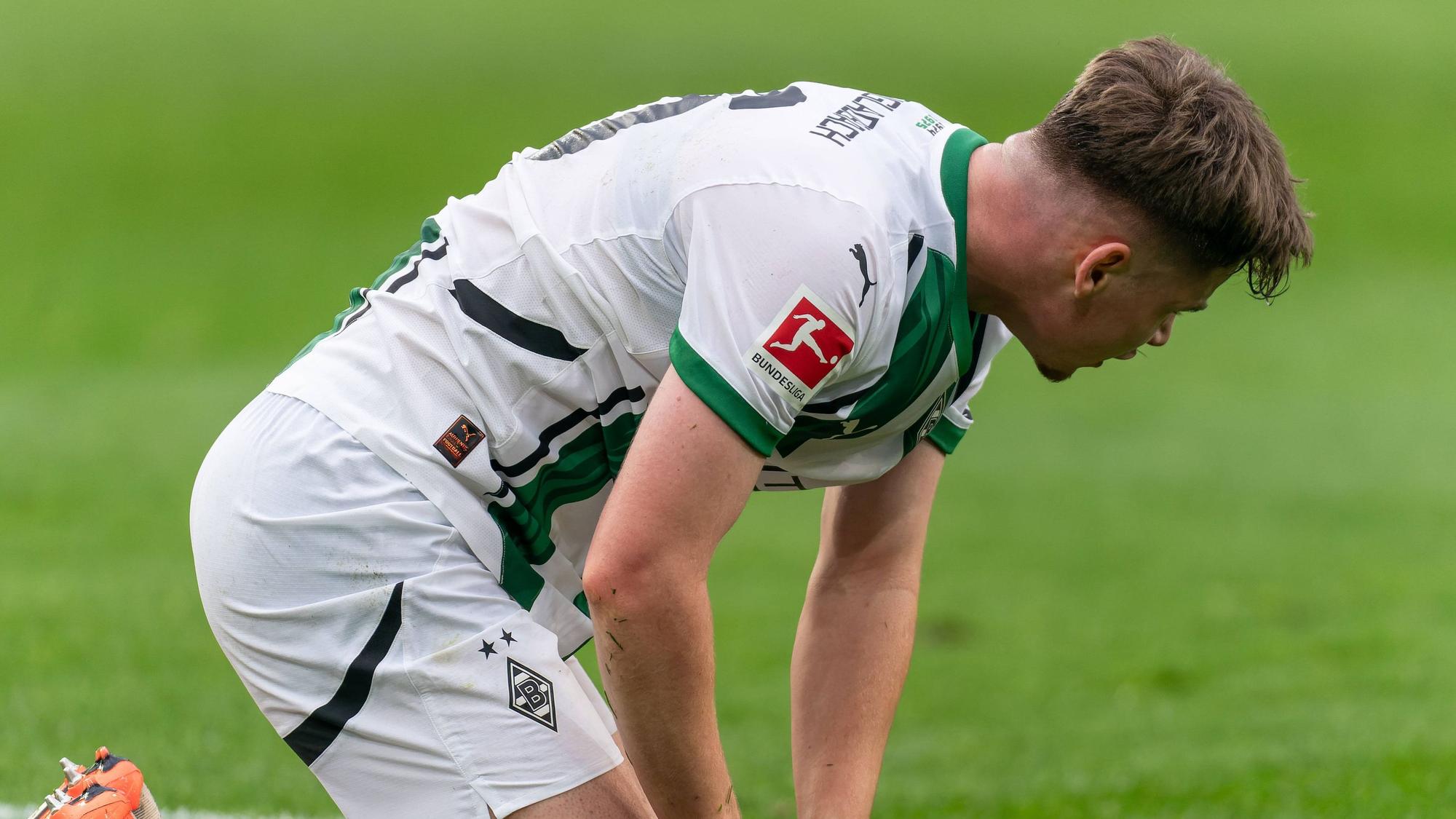 Borussia Mönchengladbachs Lukas Ullrich kniet im Bundesliga-Heimspiel gegen den FC Augsburg auf dem Platz.