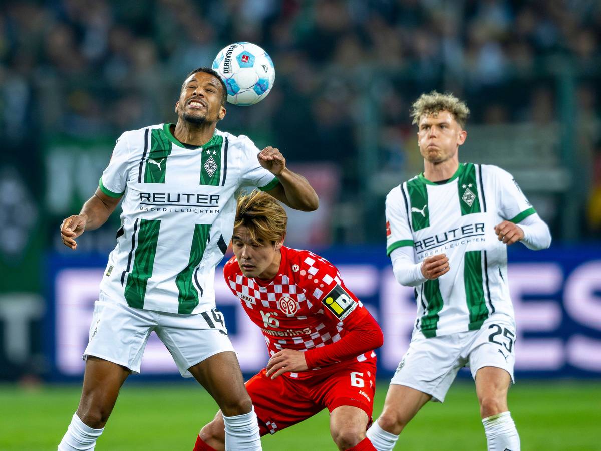 Borussia Mönchengladbachs Alassane Plea köpft den Ball, Mainz-Profi Kaishu Sano steht dahinter, Gladbachs Robin Hack beobachtet die Szene.