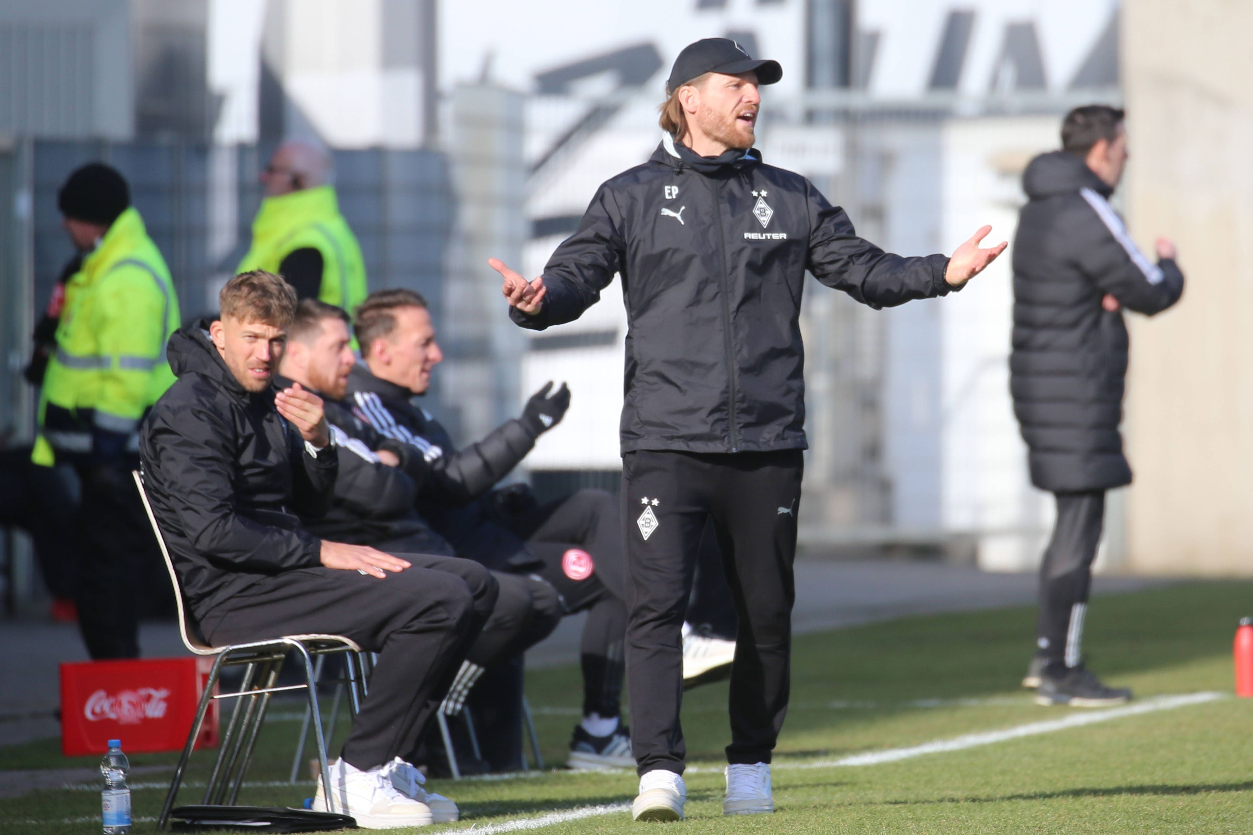 Borussia Mönchengladbachs Trainer Eugen Polanski steht beim Spiel in Düsseldorf mit ausgebreiteten Armen an der Seitenlinie und ruft auf das Spielfeld.