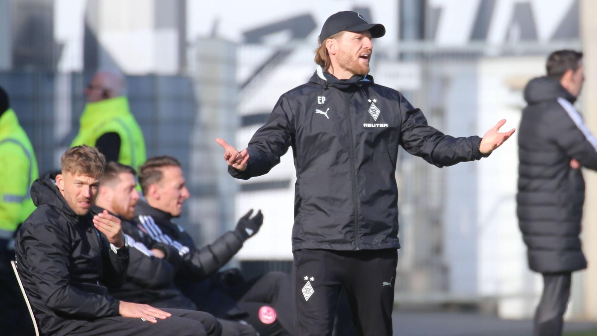 Borussia Mönchengladbachs Trainer Eugen Polanski steht beim Spiel in Düsseldorf mit ausgebreiteten Armen an der Seitenlinie und ruft auf das Spielfeld.