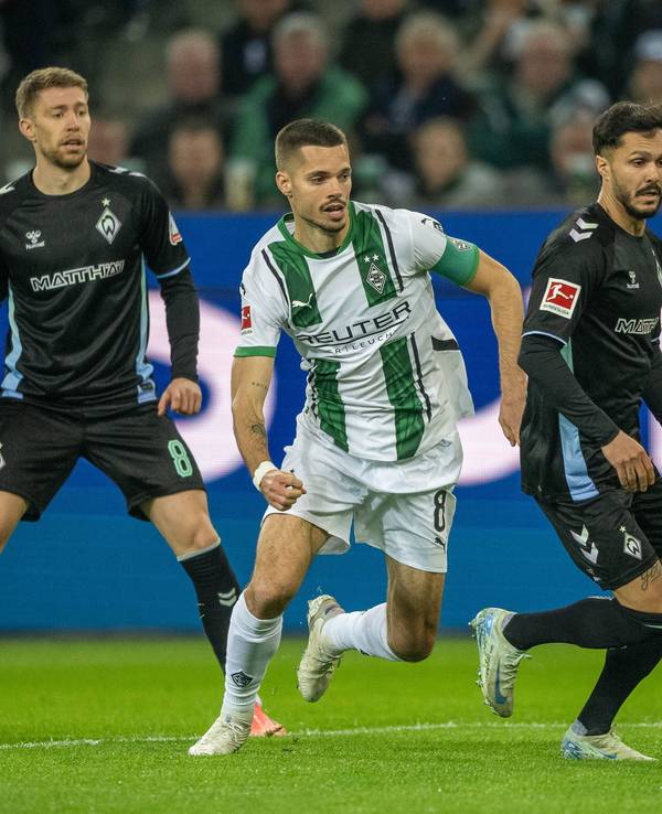 Borussia Mönchengladbachs Julian Weigl steht hinter Bremens Leonardo Bittencourt und hat den Ball im Blick, im Hintergrund beobachtet Werders Mitchell Weiser die Szene.