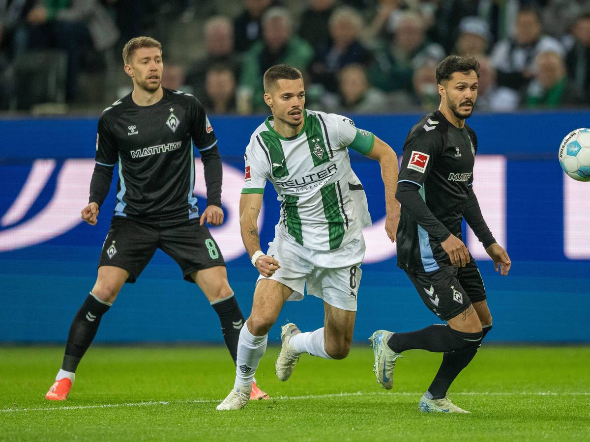 Borussia Mönchengladbachs Julian Weigl steht hinter Bremens Leonardo Bittencourt und hat den Ball im Blick, im Hintergrund beobachtet Werders Mitchell Weiser die Szene.