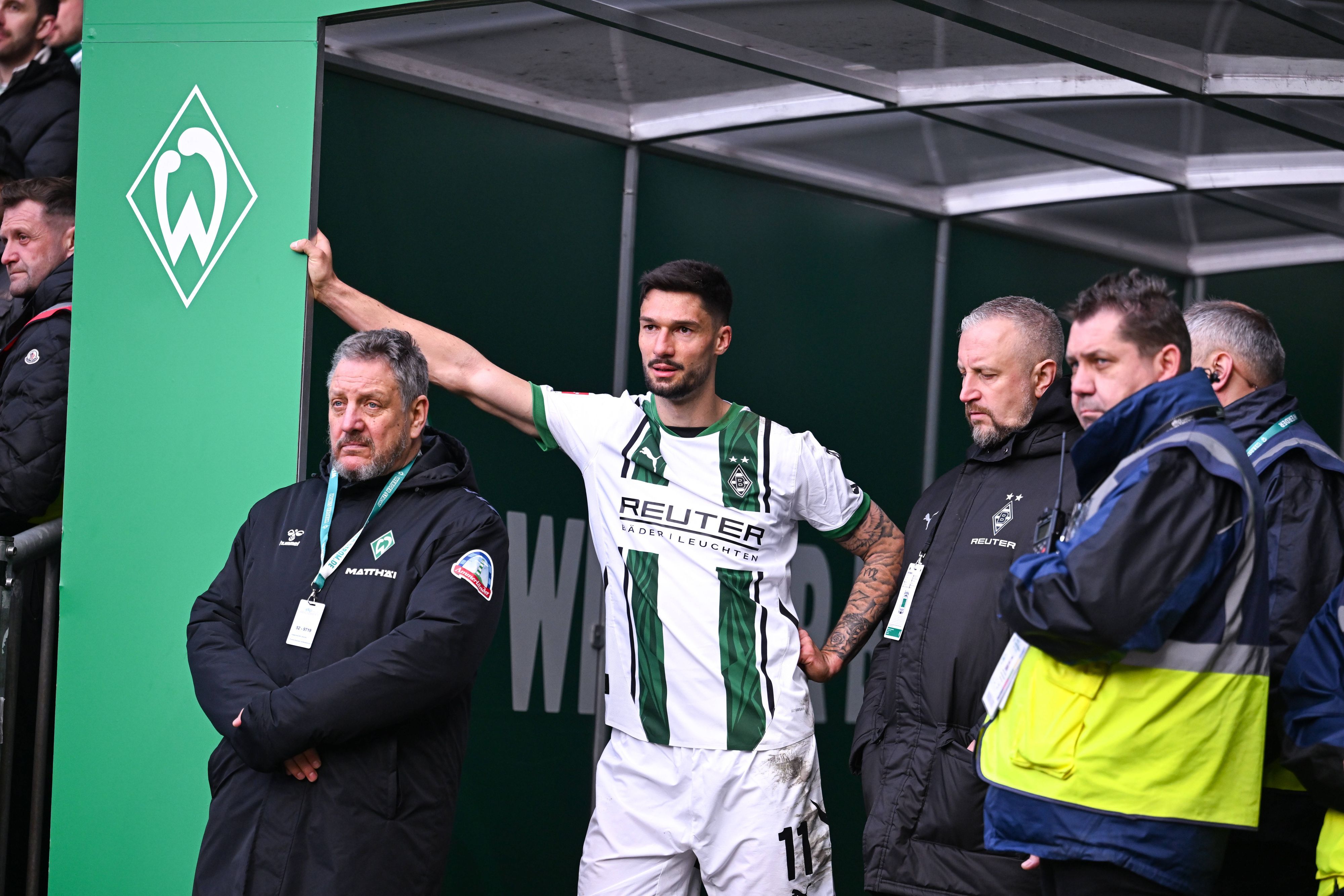 Borussia Mönchengladbachs Tim Kleindienst lehnt im Bremer Weserstadion mit einem Arm am Eingang zum Kabinentrakt und blickt auf das Spielfeld.