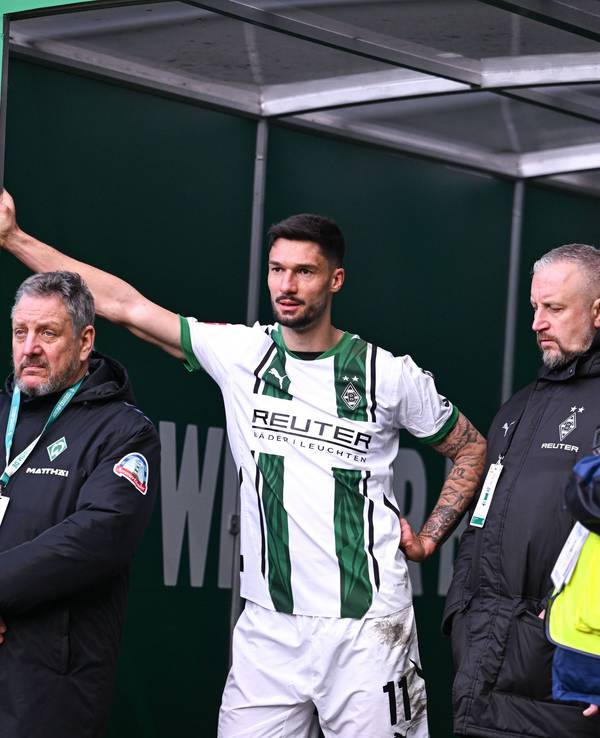 Borussia Mönchengladbachs Tim Kleindienst lehnt im Bremer Weserstadion mit einem Arm am Eingang zum Kabinentrakt und blickt auf das Spielfeld.