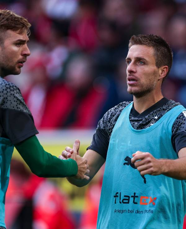 Die Gladbach-Reservisten Christoph Kramer und Patrick Herrmann klatschen sich während des Spiels beim 1. FC Köln auf dem Platz ab.