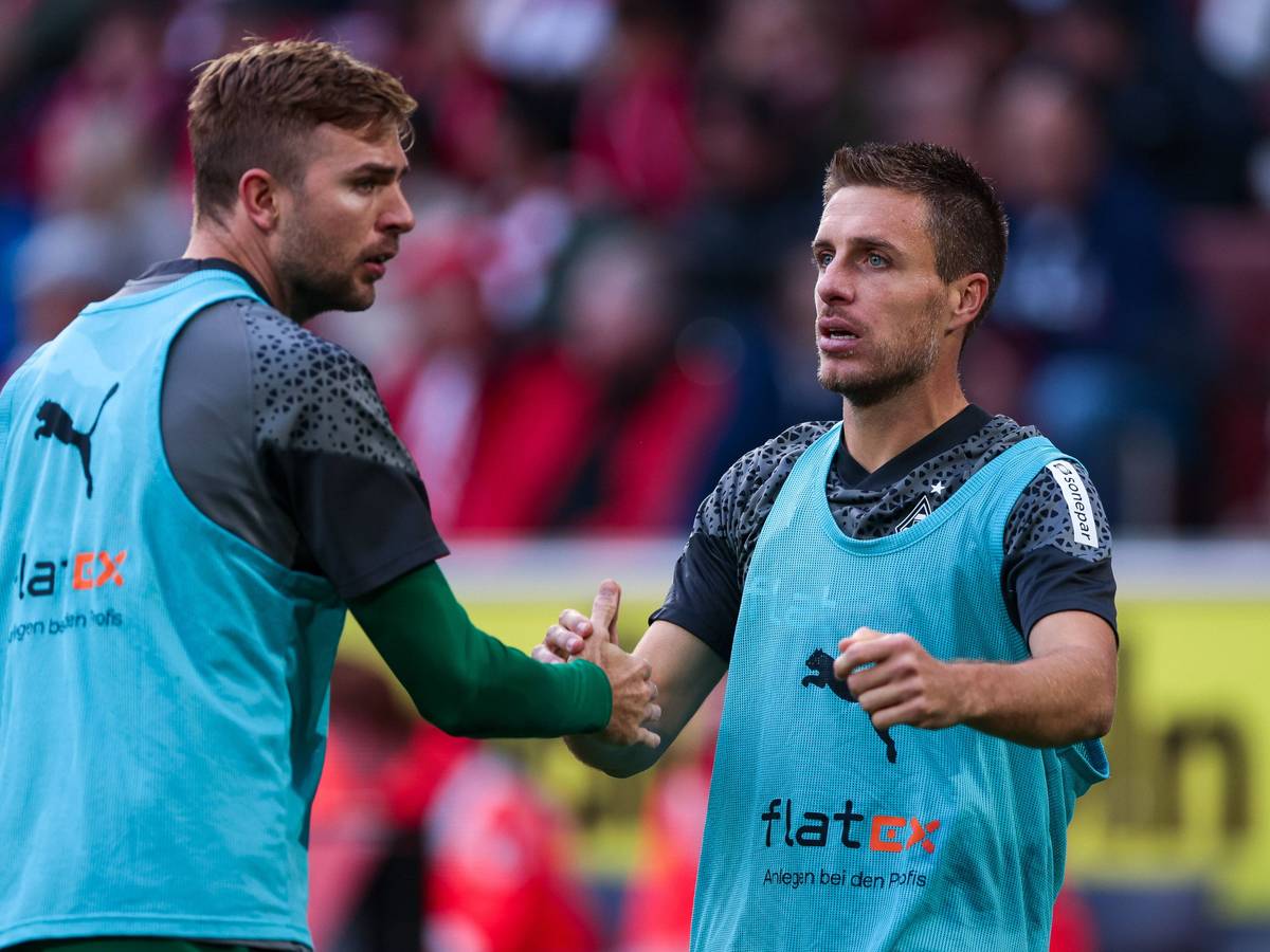 Die Gladbach-Reservisten Christoph Kramer und Patrick Herrmann klatschen sich während des Spiels beim 1. FC Köln auf dem Platz ab.