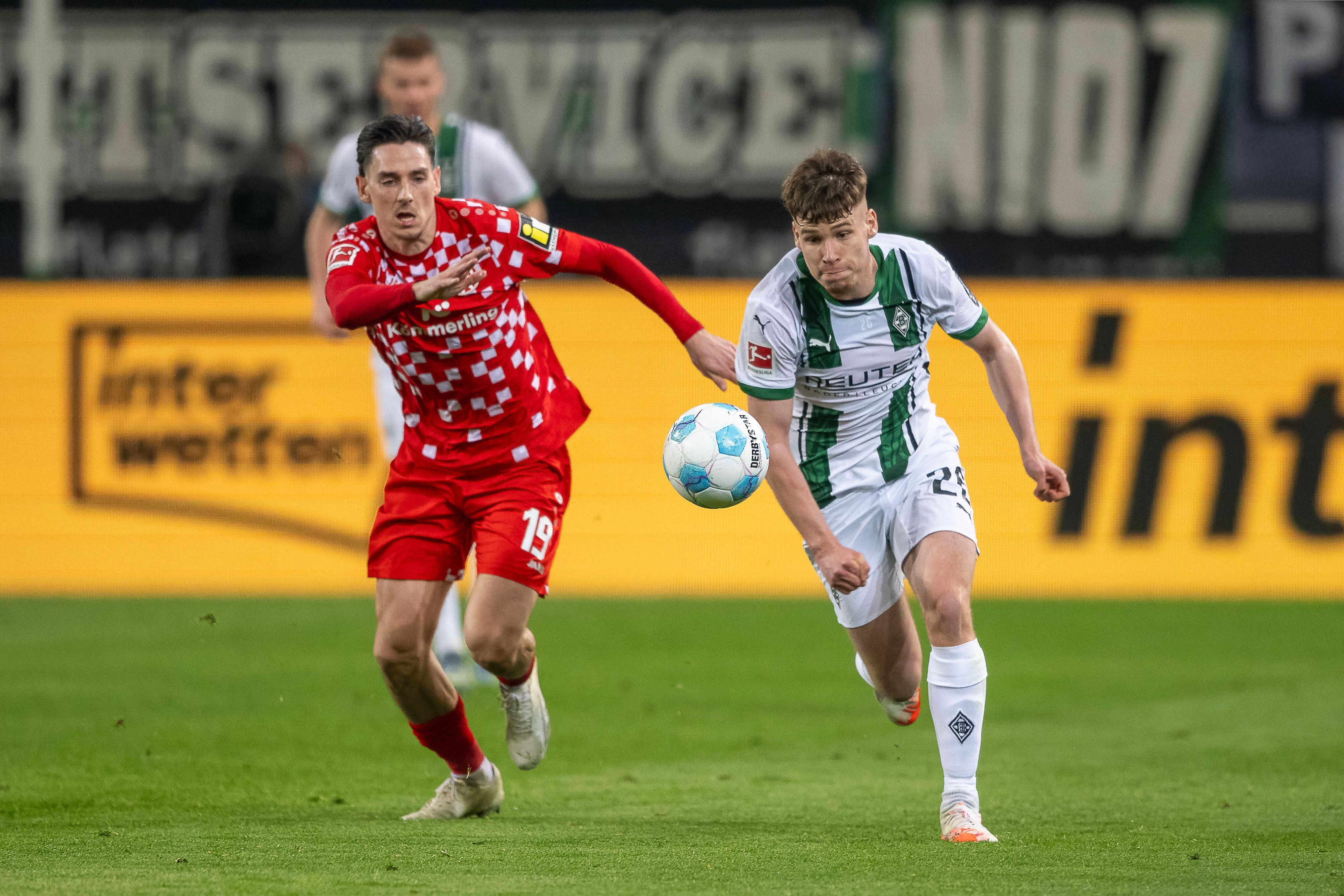 Borussia Mönchengladbachs Lukas Ullrich treibt den Ball, der Mainzer Anthony Caci verfolgt ihn.