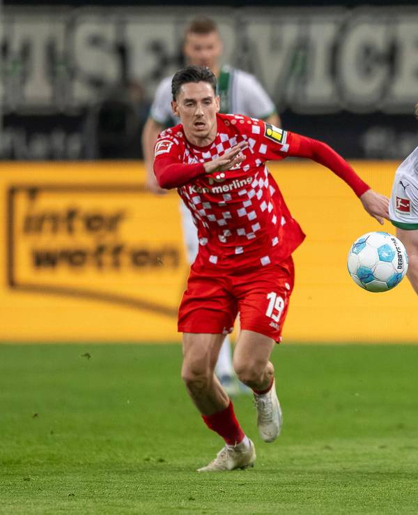 Borussia Mönchengladbachs Lukas Ullrich treibt den Ball, der Mainzer Anthony Caci verfolgt ihn.