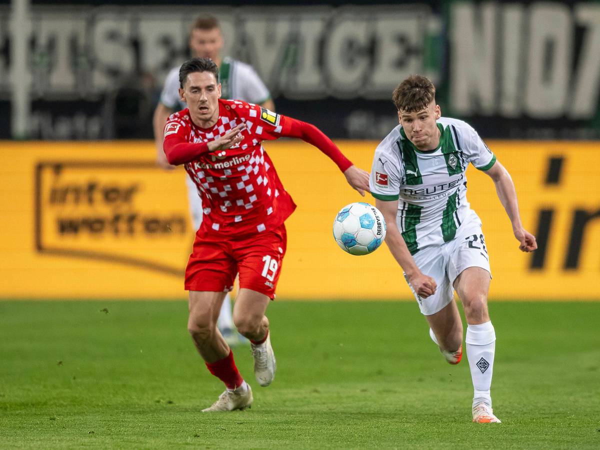 Borussia Mönchengladbachs Lukas Ullrich treibt den Ball, der Mainzer Anthony Caci verfolgt ihn.