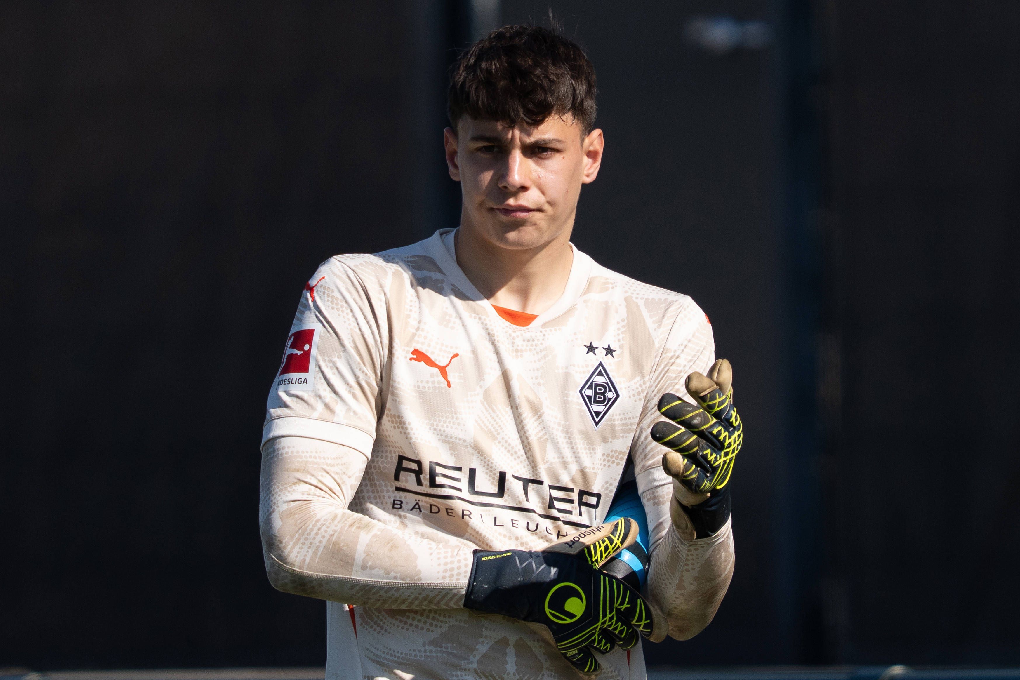 Borussia Mönchengladbachs Torwart Maximilian Neutgens richtet sich während des Testspiels gegen Viktoria Köln die Handschuhe.
