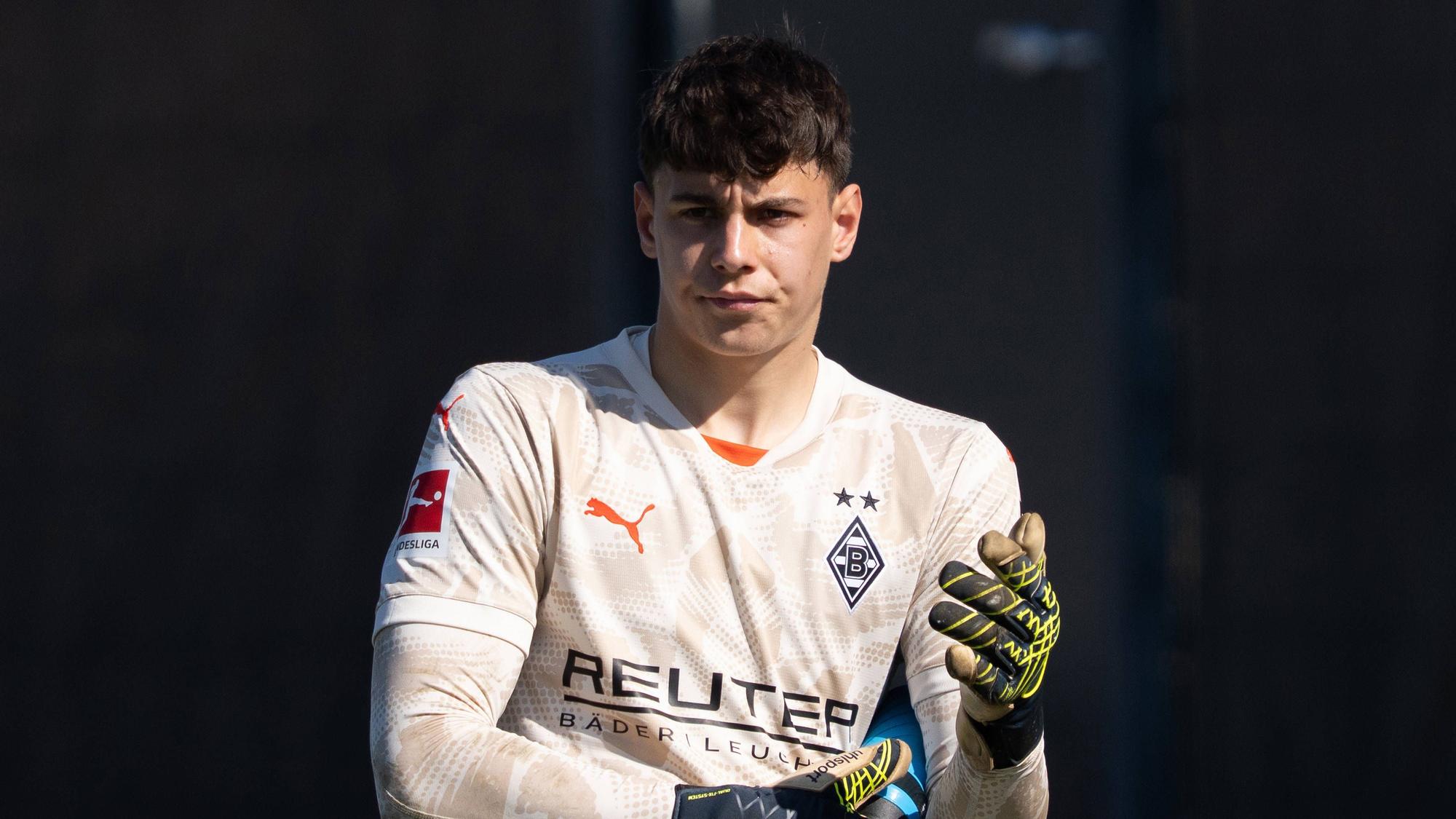 Borussia Mönchengladbachs Torwart Maximilian Neutgens richtet sich während des Testspiels gegen Viktoria Köln die Handschuhe.