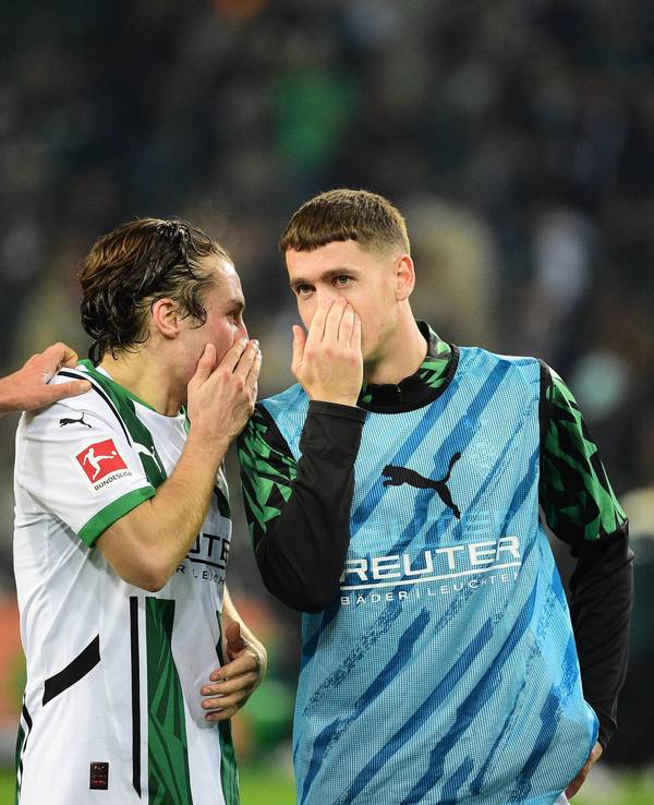 Die Gladbach-Profis Rocco Reitz und Philipp Sander unterhalten sich nach dem Bundesliga-Heimspiel gegen Werder Bremen mit vorgehaltener Hand vor dem Mund.