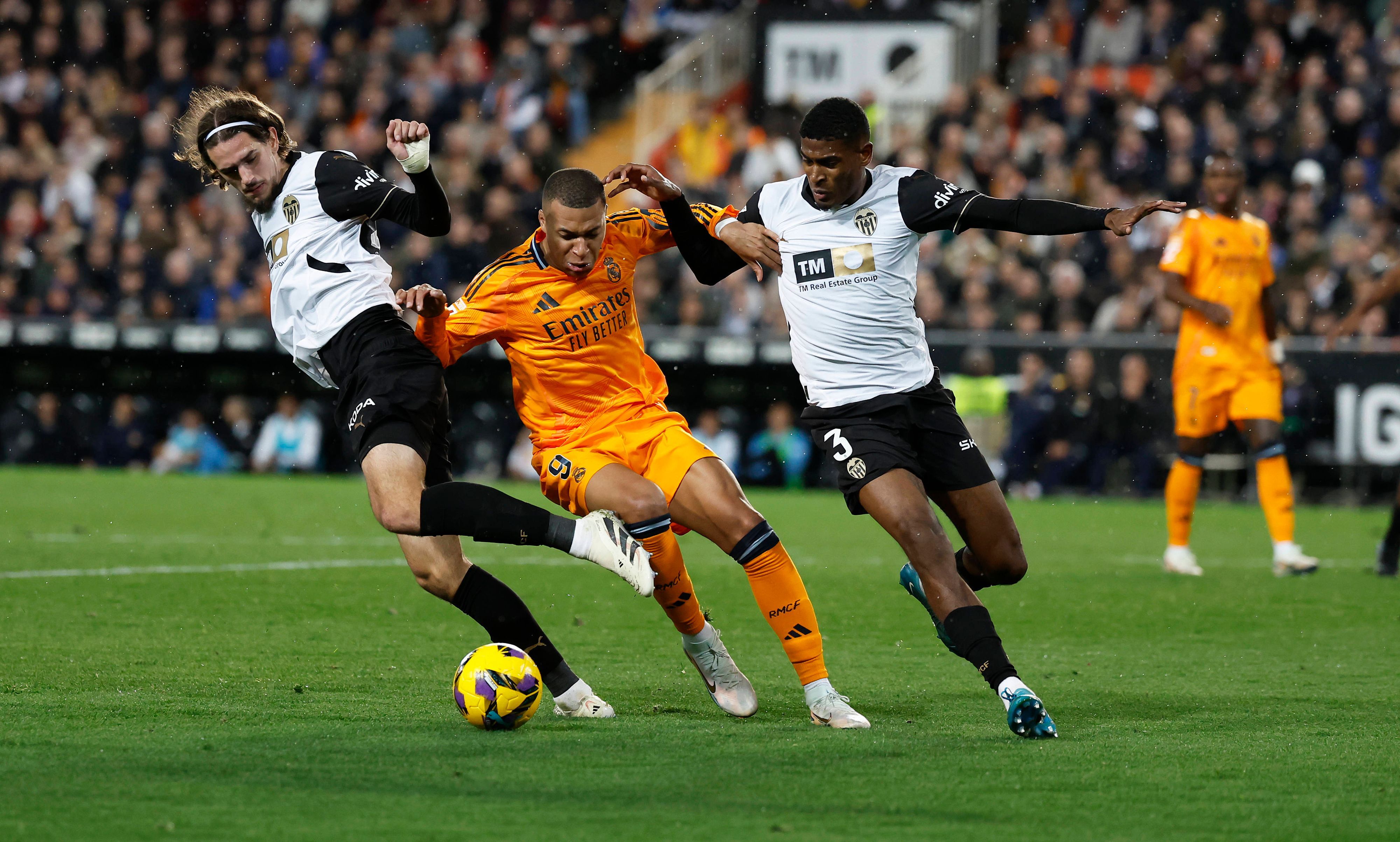 Die Valencia-Profis Cristhian Mosquera und Yarek Gasiorowski kämpfen mit Real Madrids Kylian Mbappé um den Ball.