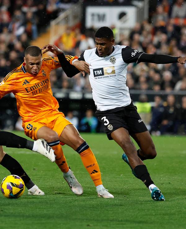 Die Valencia-Profis Cristhian Mosquera und Yarek Gasiorowski kämpfen mit Real Madrids Kylian Mbappé um den Ball.