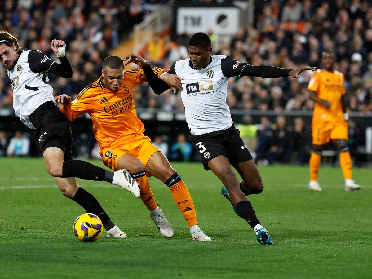 Die Valencia-Profis Cristhian Mosquera und Yarek Gasiorowski kämpfen mit Real Madrids Kylian Mbappé um den Ball.