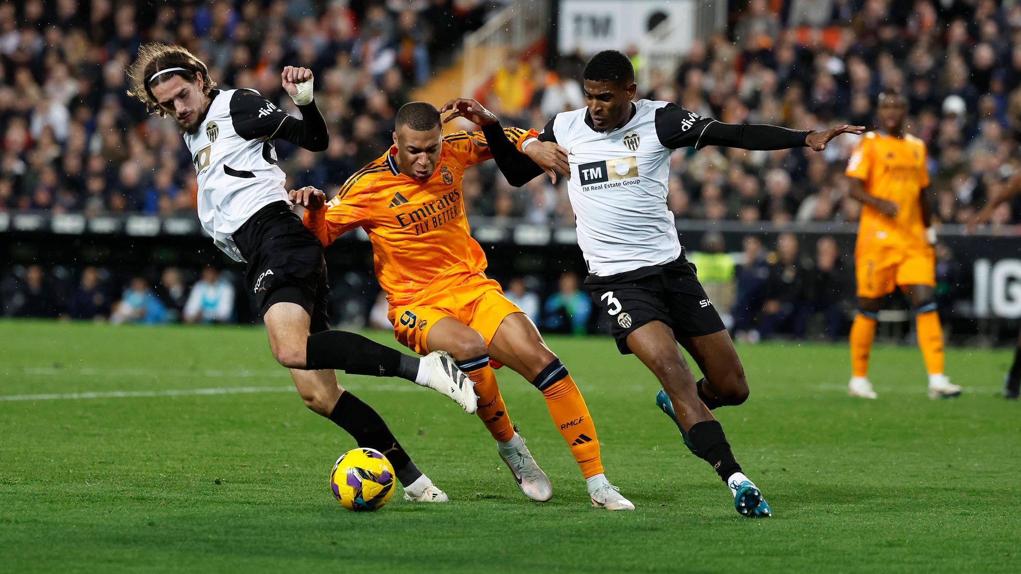 Die Valencia-Profis Cristhian Mosquera und Yarek Gasiorowski kämpfen mit Real Madrids Kylian Mbappé um den Ball.
