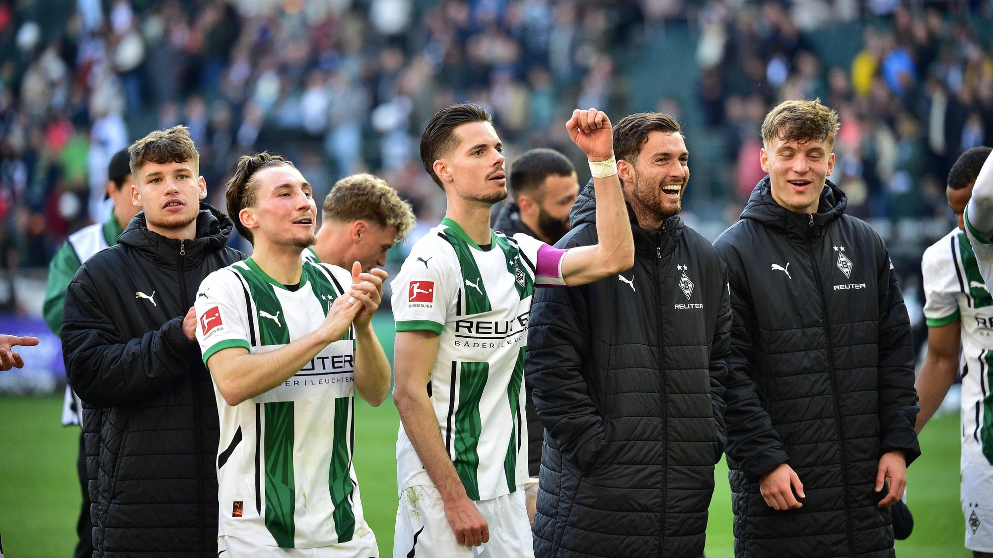Spieler von Borussia Mönchengladbach feiern mit den Fans nach einem Sieg.