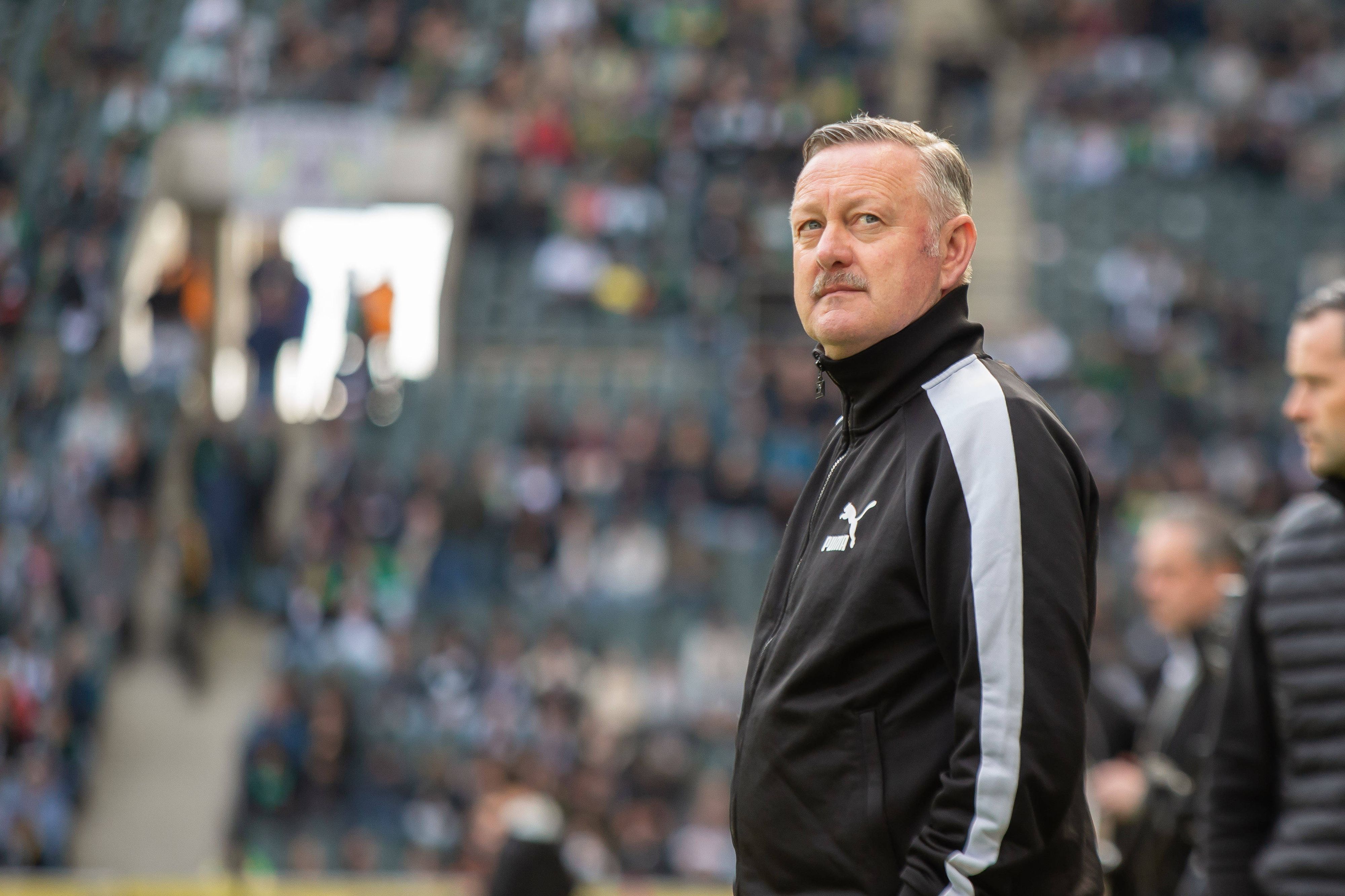 Roland Virkus schaut vor einem Bundesliga-Spiel konzentriert nach oben.