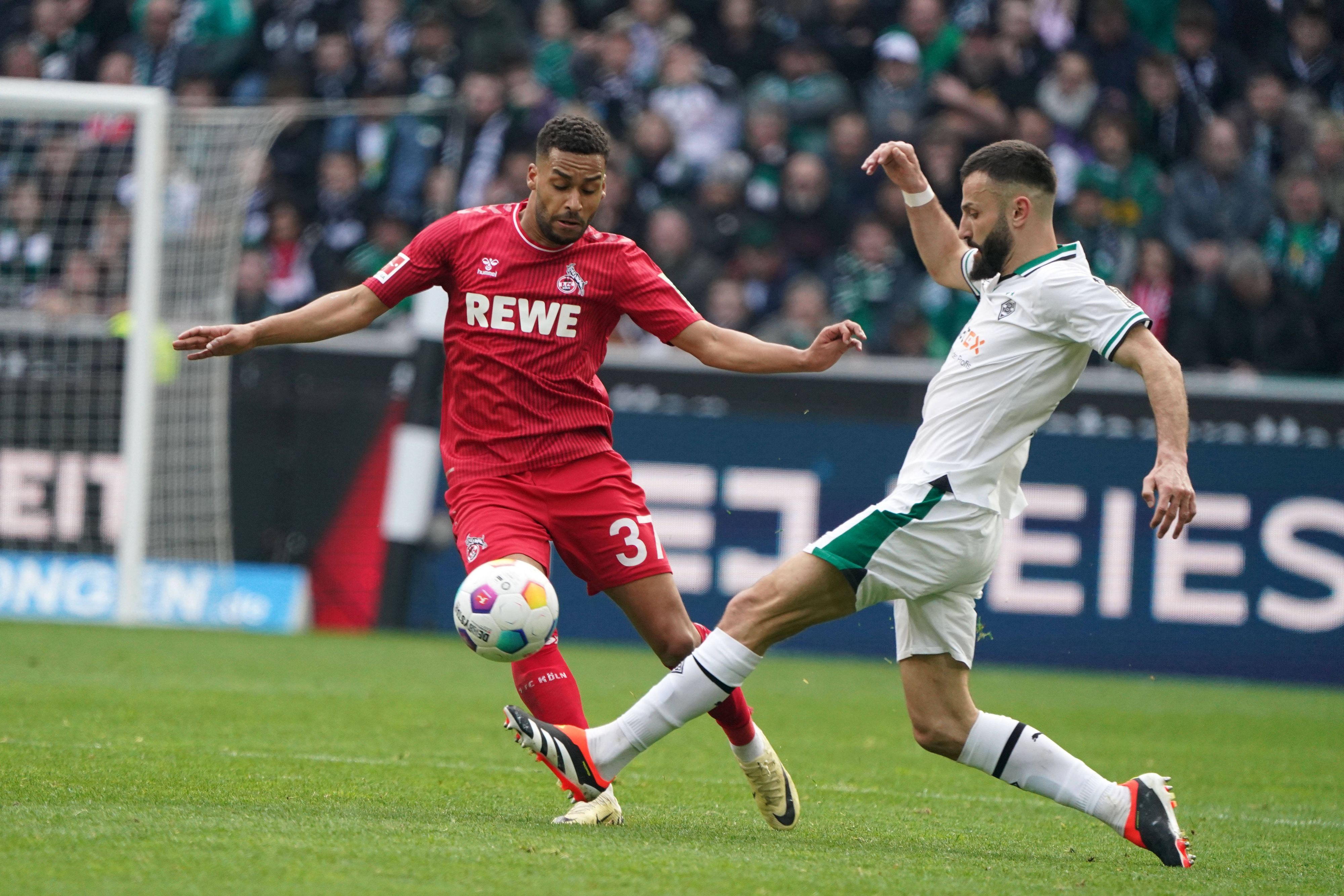 Linton Maina lupft den Ball über Franck Honorats Bein.