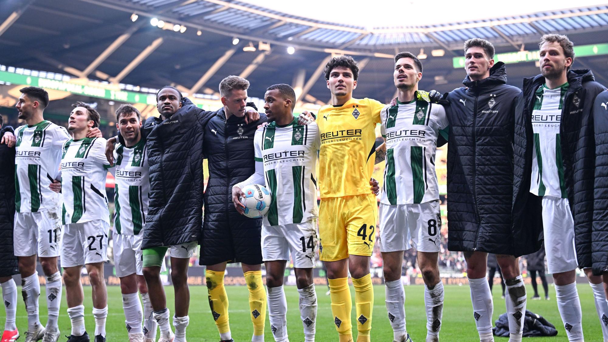 Spieler von Borussia Mönchengladbach feiern den Sieg gegen Werder Bremen mit den Fans.
