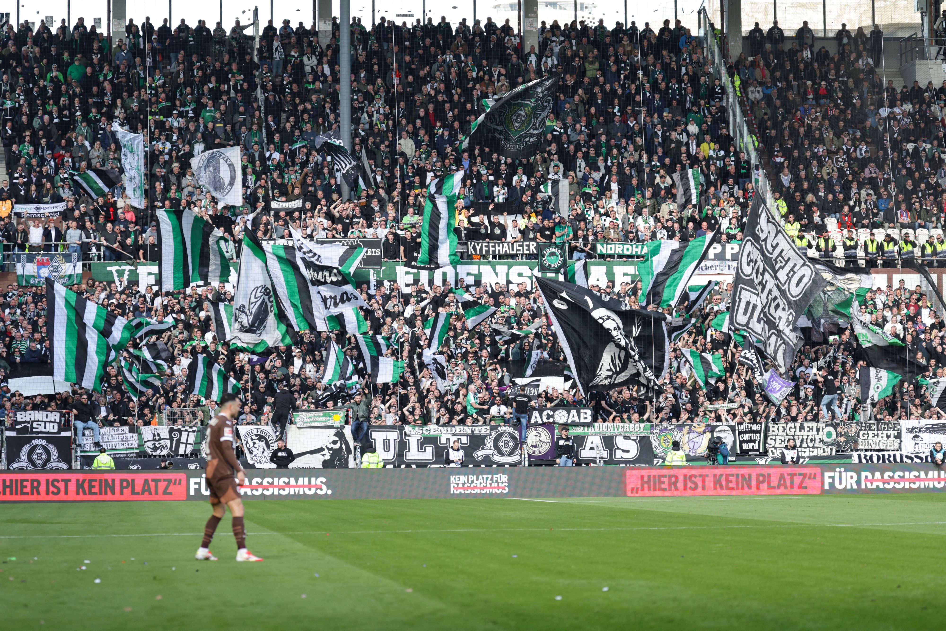 Gladbacher Auswärtsfans auf St. Pauli. Vorne steht auf einer Bande „Hier ist kein Platz für Rassismus.“