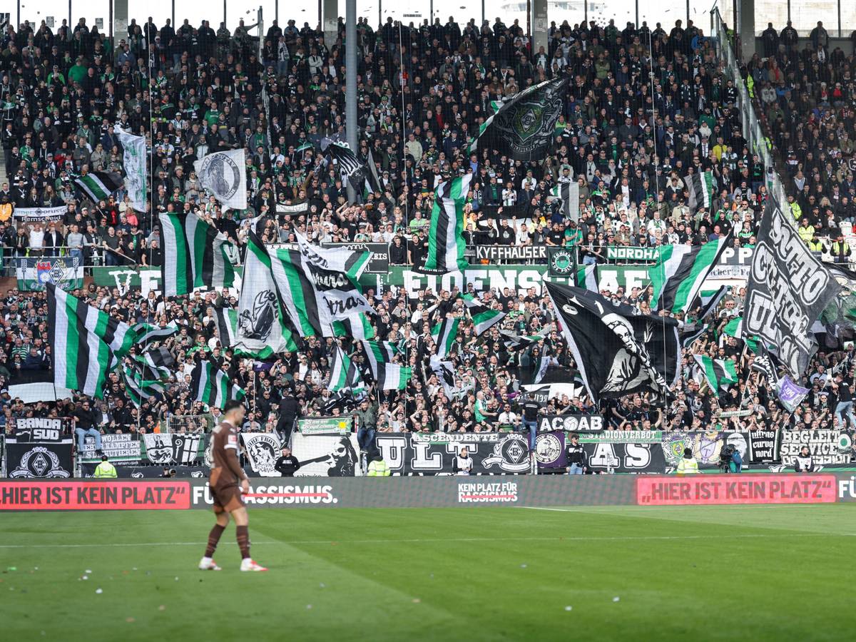 Gladbacher Auswärtsfans auf St. Pauli. Vorne steht auf einer Bande „Hier ist kein Platz für Rassismus.“