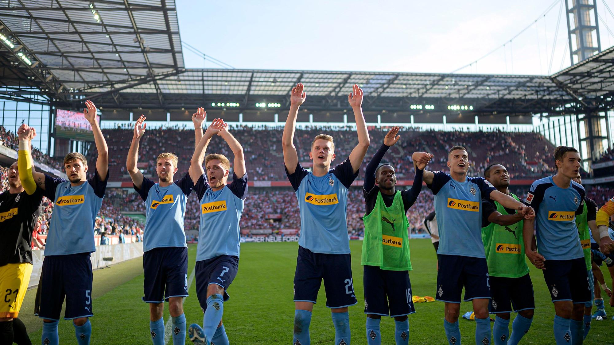Die Spieler von Borussia Mönchengladbach machen die La-Ola vor den Fans.