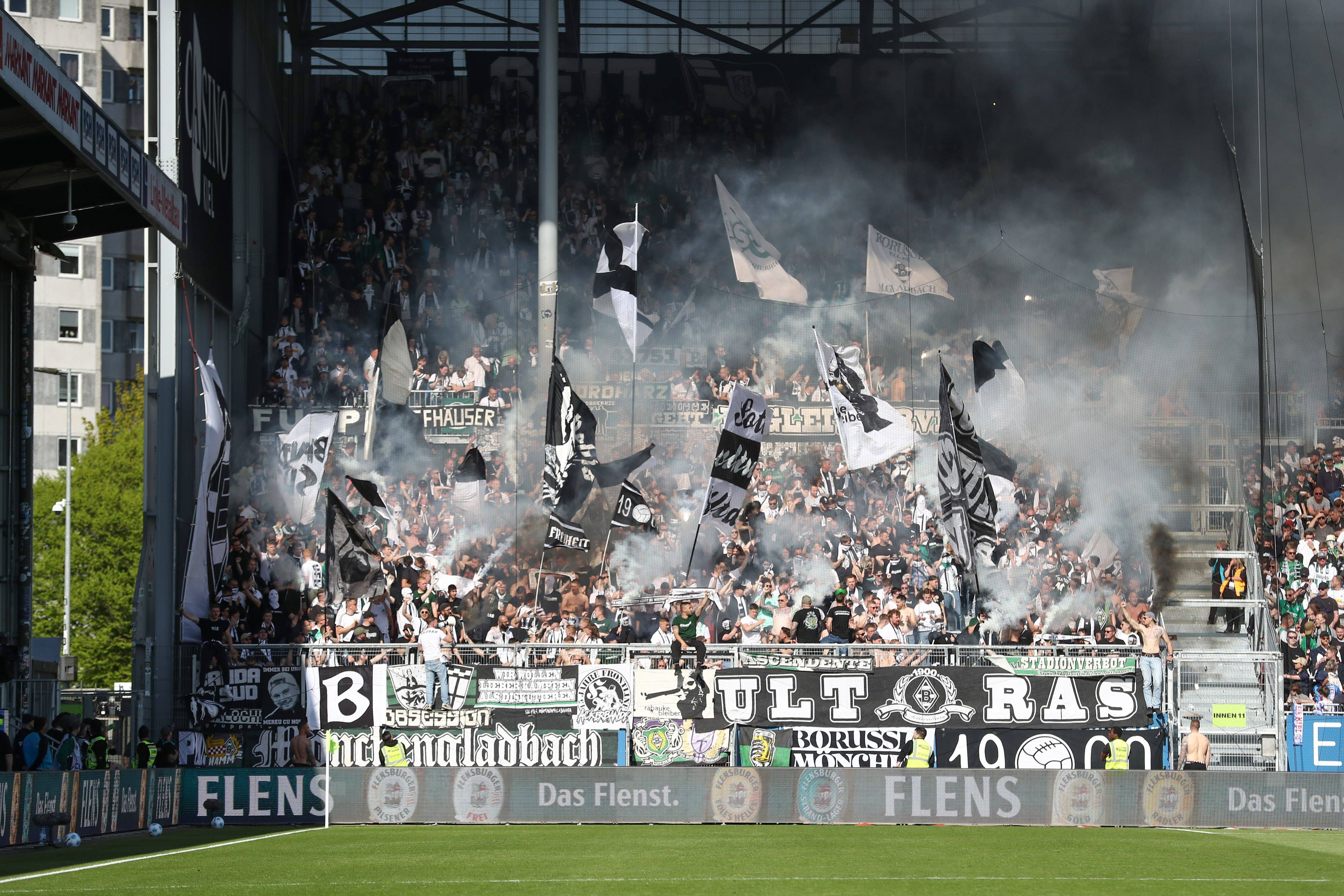 Gladbach-Fans wedeln Fähnchen und zünden Rauchbomben.