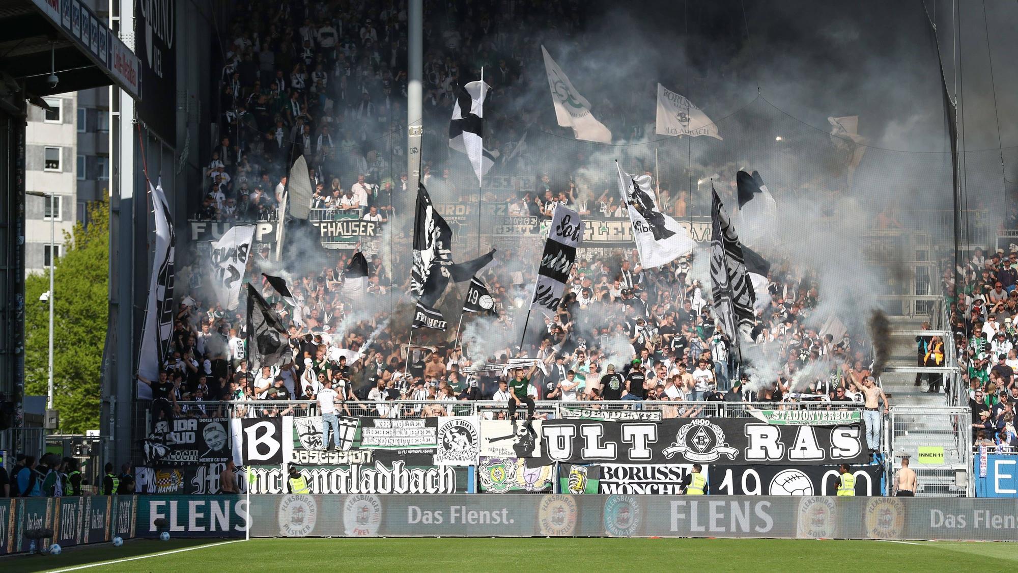 Gladbach-Fans wedeln Fähnchen und zünden Rauchbomben.