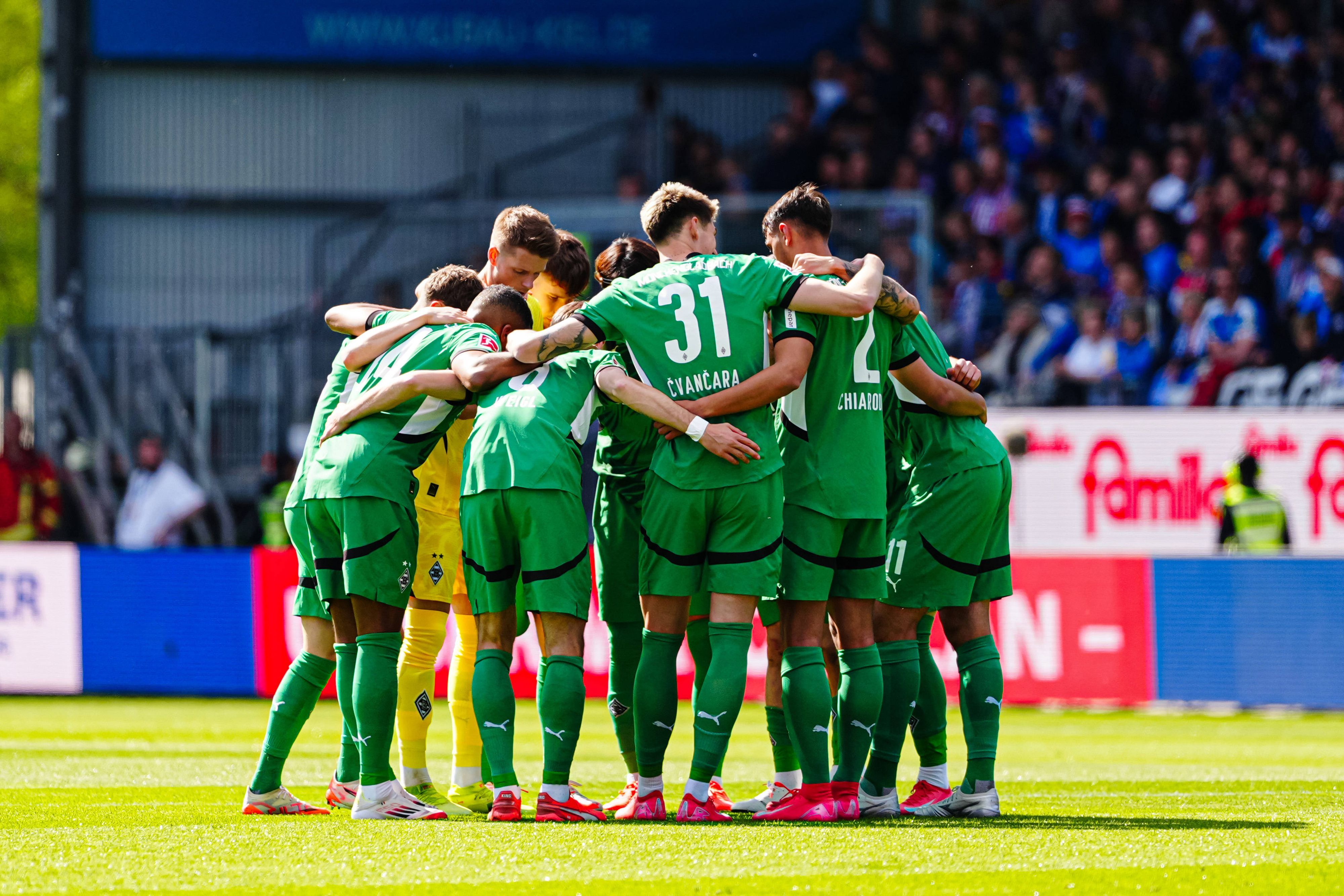 Spieler von Borussia Mönchengladbach bilden einen Kreis vor dem Spiel gegen Holstein Kiel.
