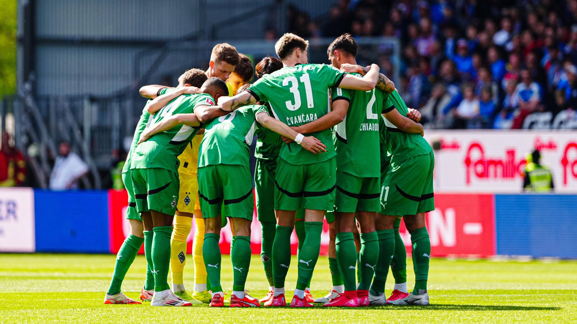 Spieler von Borussia Mönchengladbach bilden einen Kreis vor dem Spiel gegen Holstein Kiel.