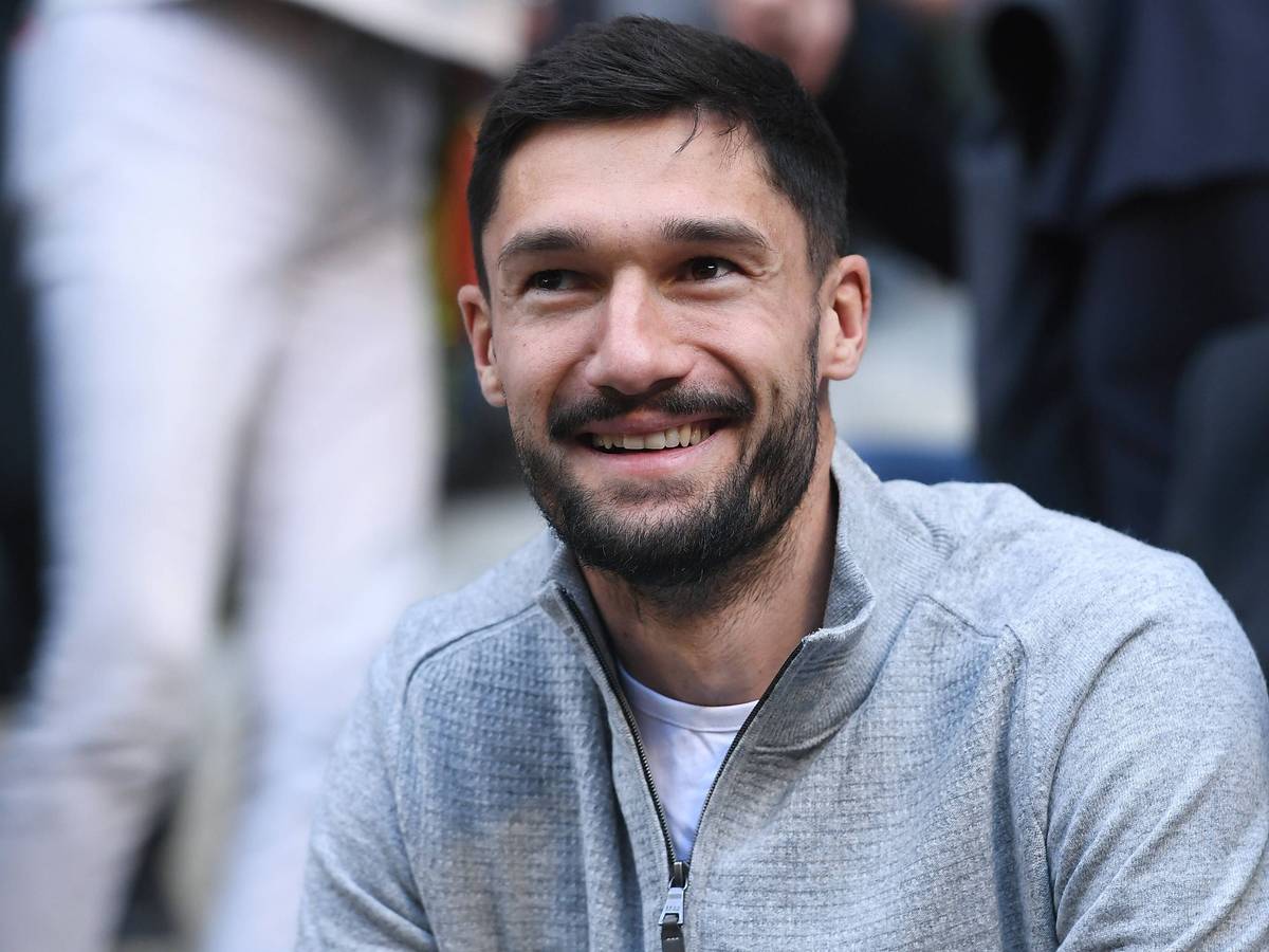 Tim Kleindienst lächelt in privater Kleidung auf der Tribüne.