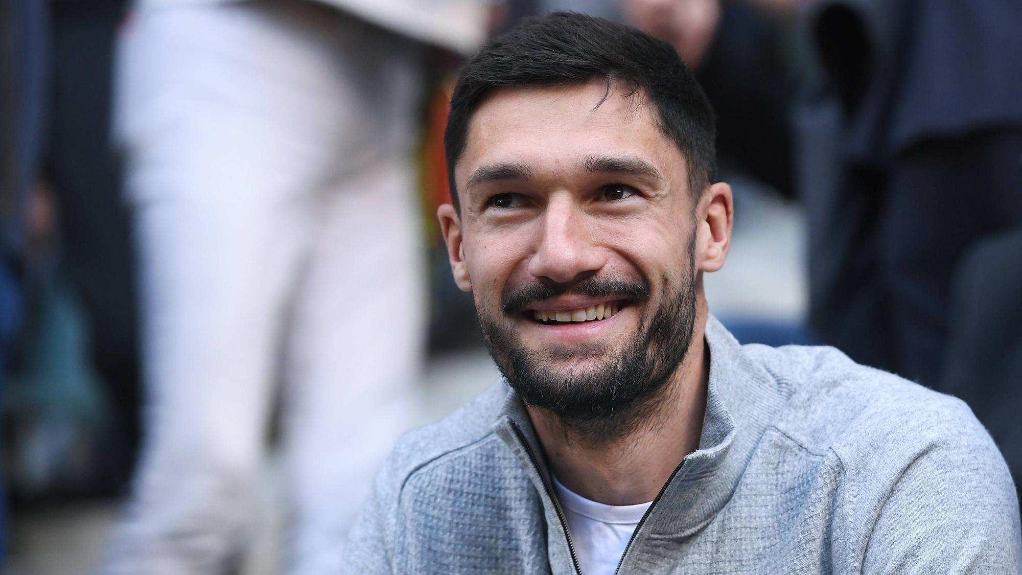 Tim Kleindienst lächelt in privater Kleidung auf der Tribüne.
