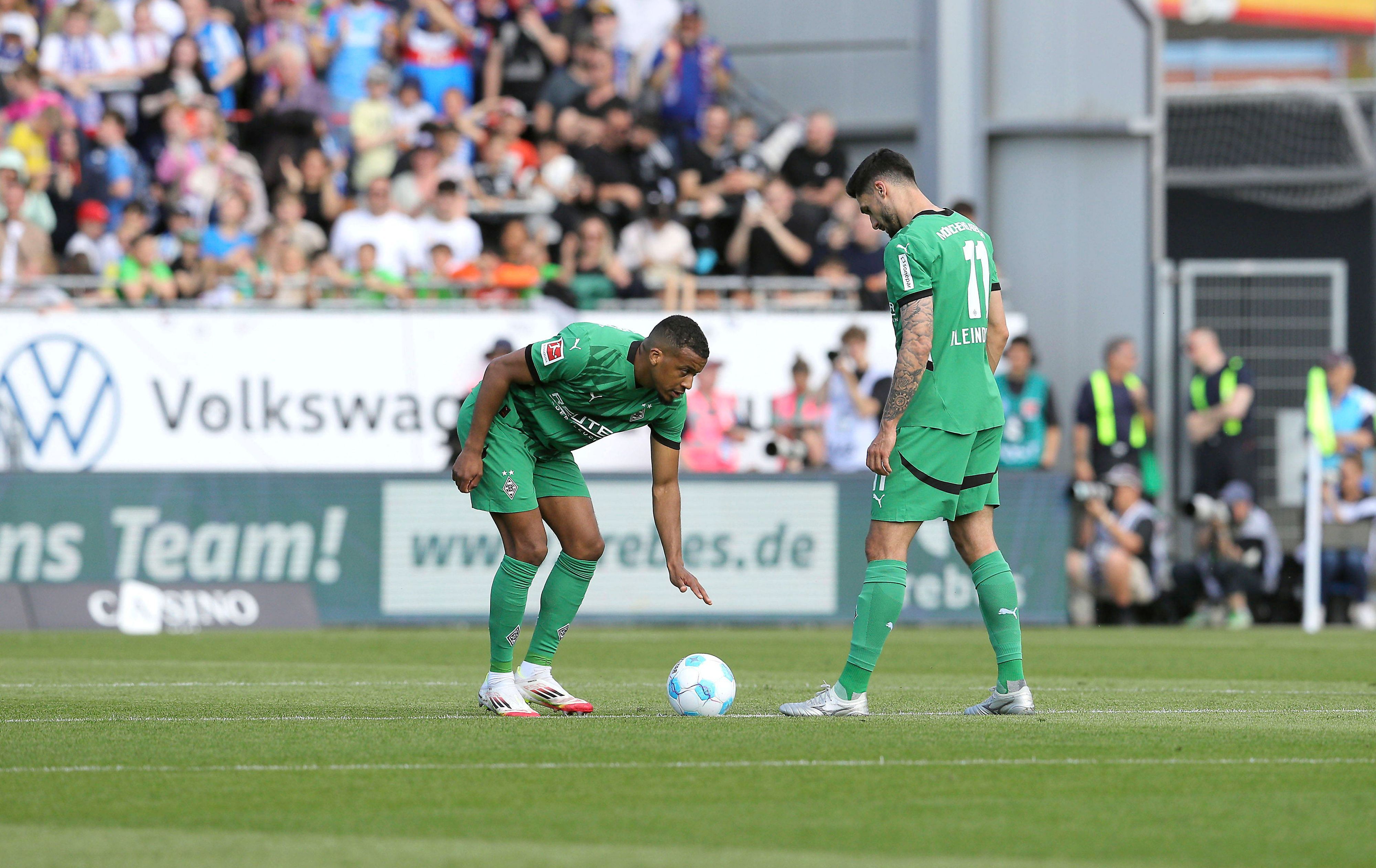 Alassane Plea bückt sich zum Anstoß, Kleindienst steht daneben.