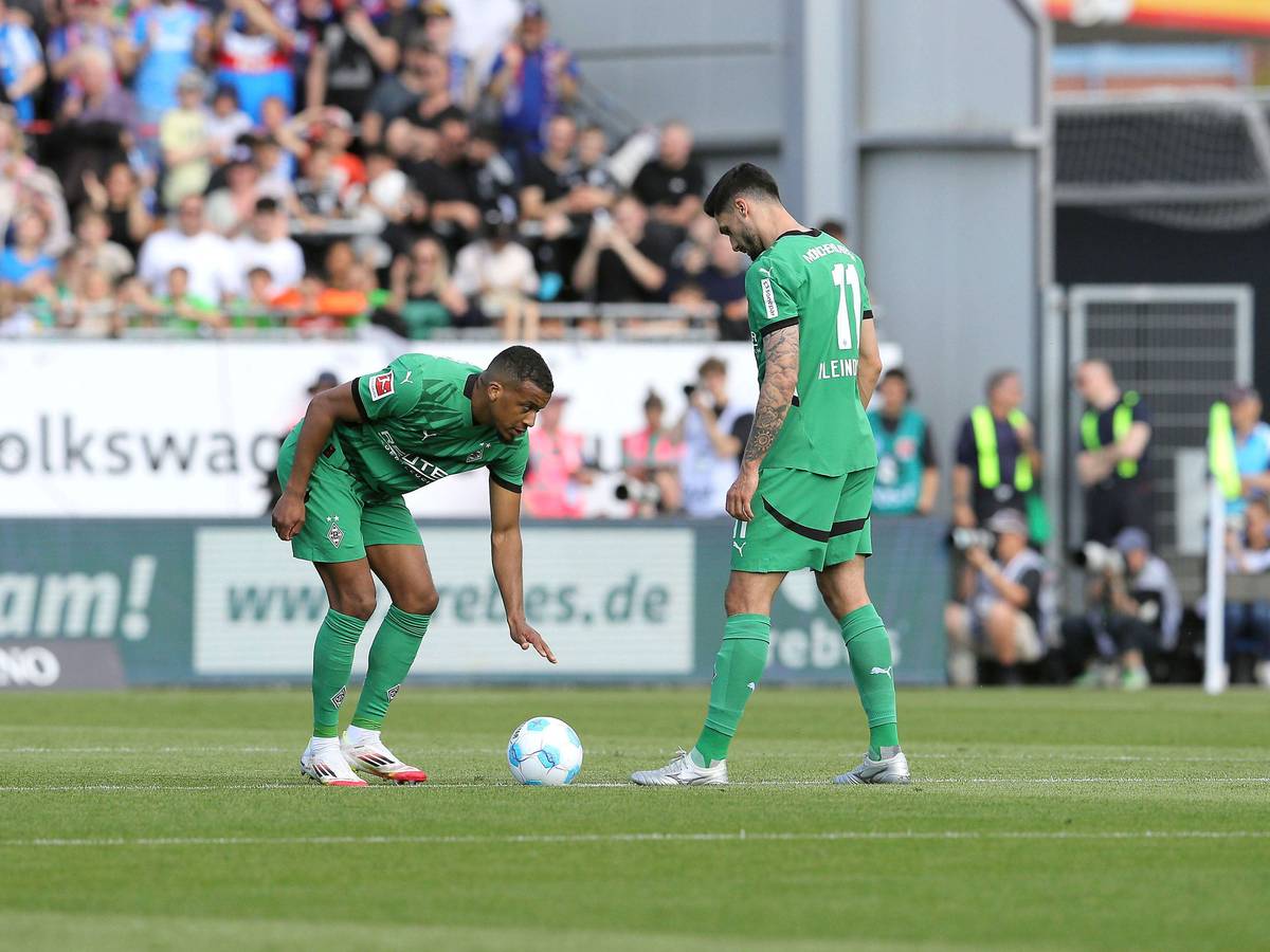 Alassane Plea bückt sich zum Anstoß, Kleindienst steht daneben.