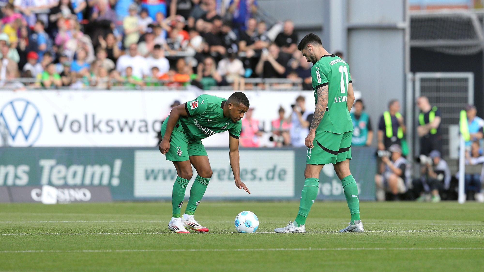 Alassane Plea bückt sich zum Anstoß, Kleindienst steht daneben.