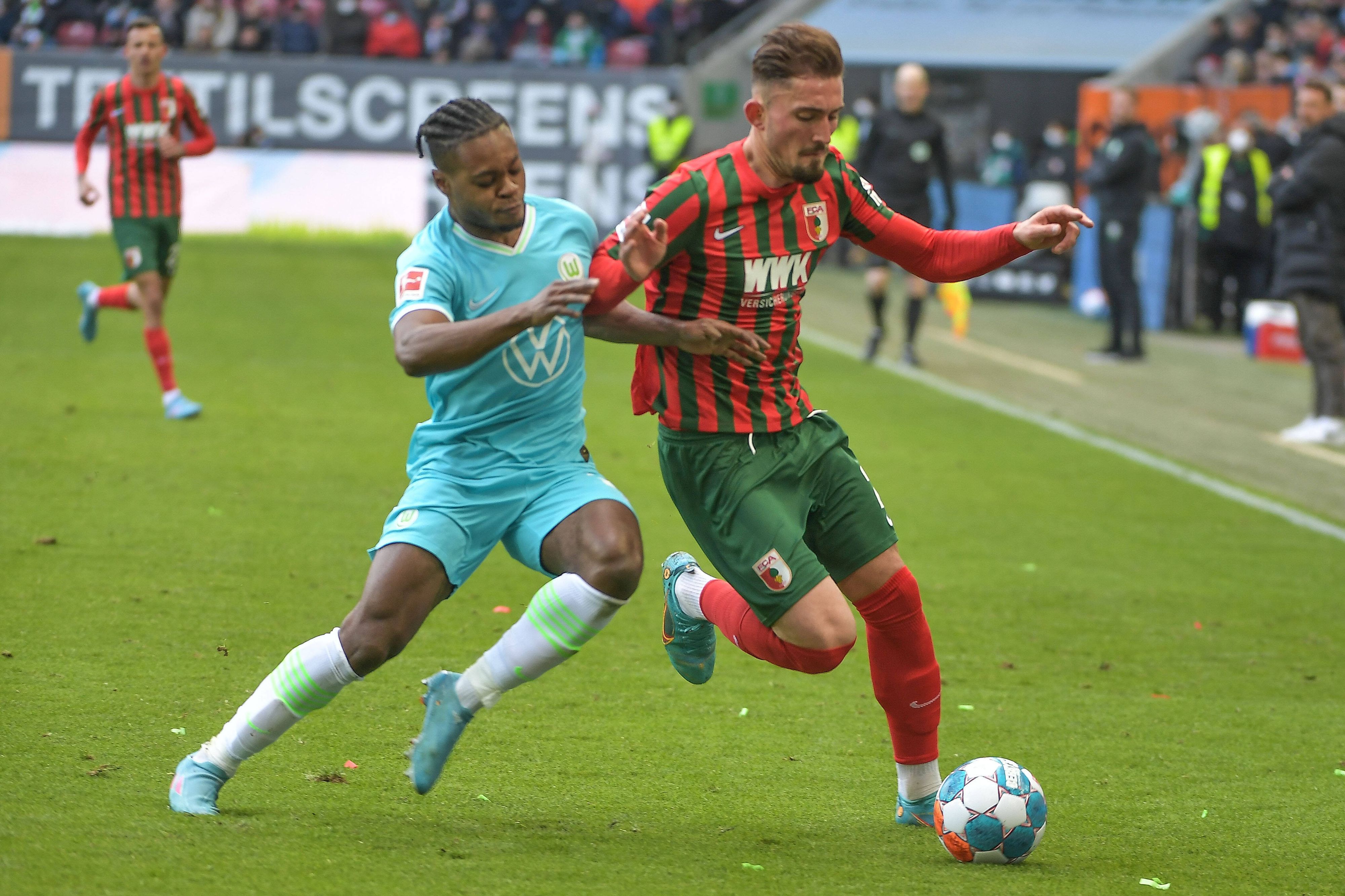 Ridle Baku und Andi Zeqiri beim Bundesliga-Duell zwischen Wolfsburg und Augsburg am 4. März 2022 im Zweikampf.