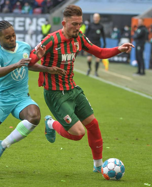 Ridle Baku und Andi Zeqiri beim Bundesliga-Duell zwischen Wolfsburg und Augsburg am 4. März 2022 im Zweikampf.