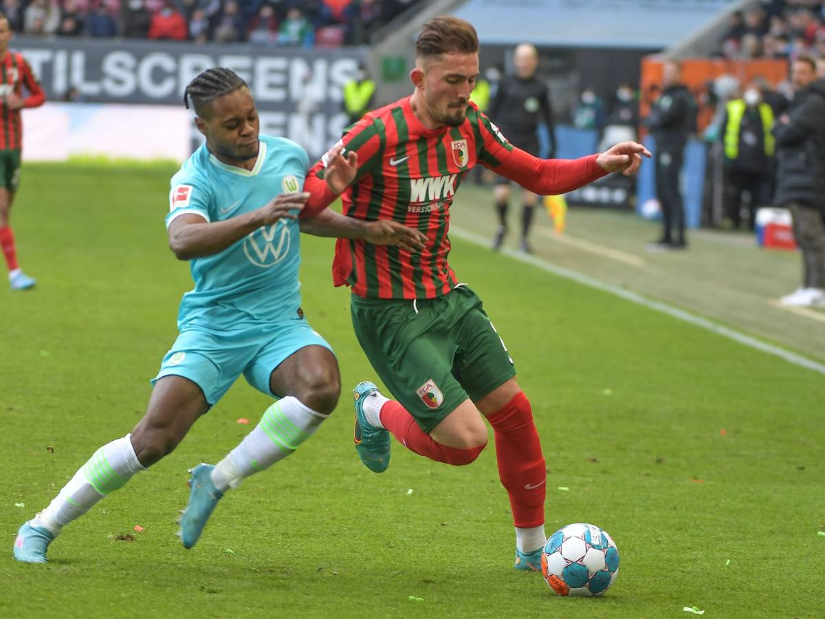 Ridle Baku und Andi Zeqiri beim Bundesliga-Duell zwischen Wolfsburg und Augsburg am 4. März 2022 im Zweikampf.