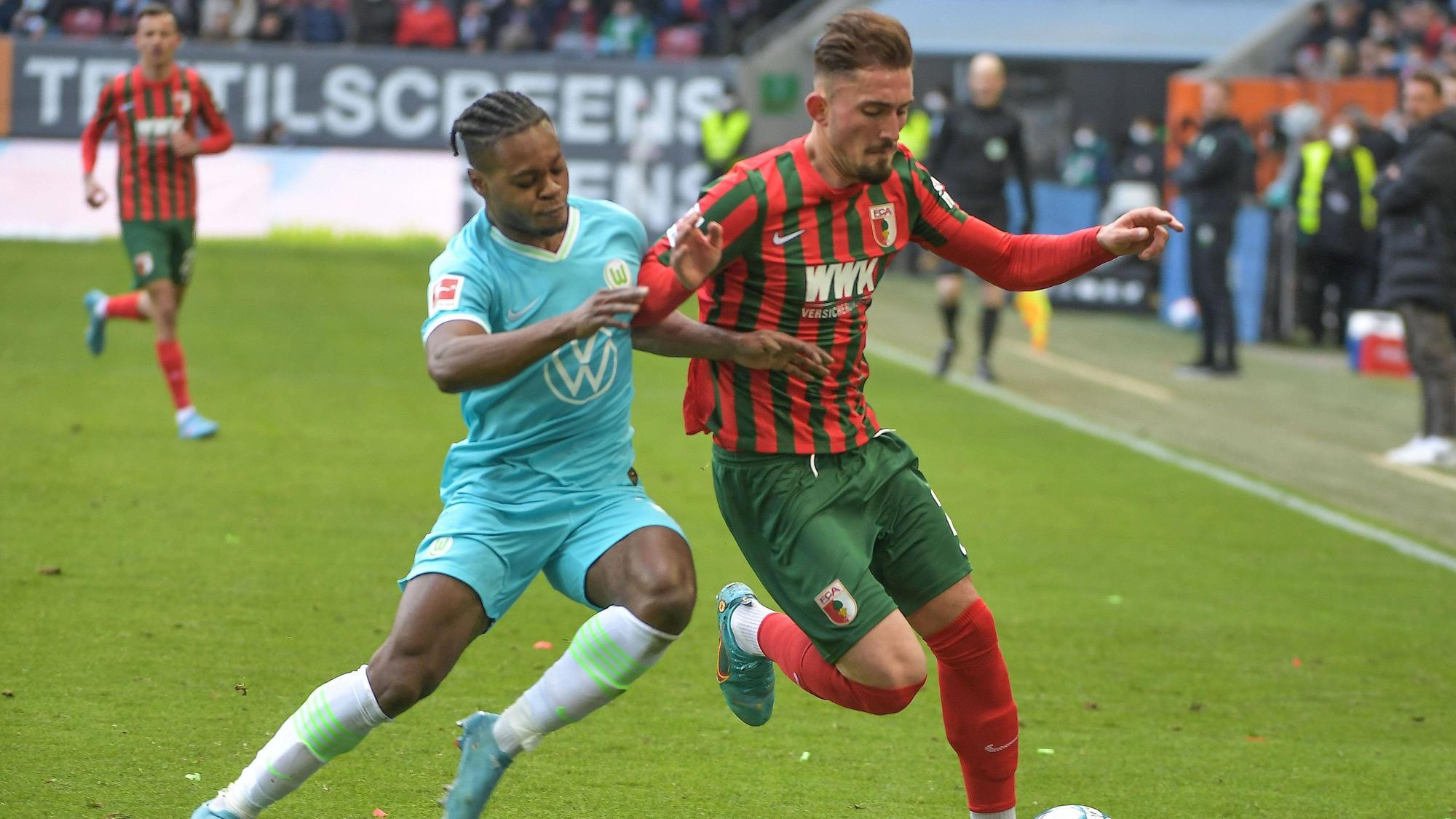 Ridle Baku und Andi Zeqiri beim Bundesliga-Duell zwischen Wolfsburg und Augsburg am 4. März 2022 im Zweikampf.