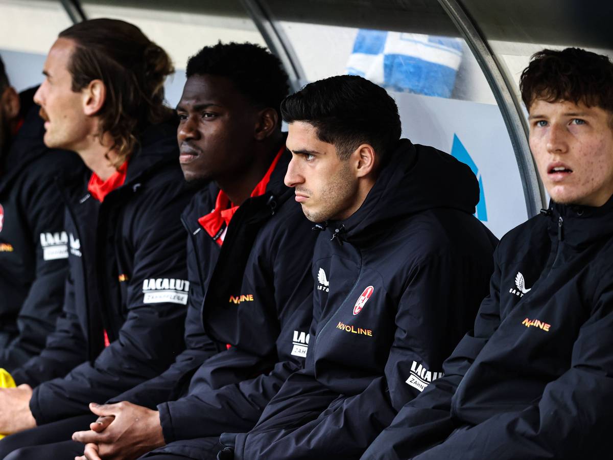 Faride Alidou und Grant Leon Ranos vom 1. FC Kaiserslautern sitzen neben ihren Teamkollegen auf der Ersatzbank.