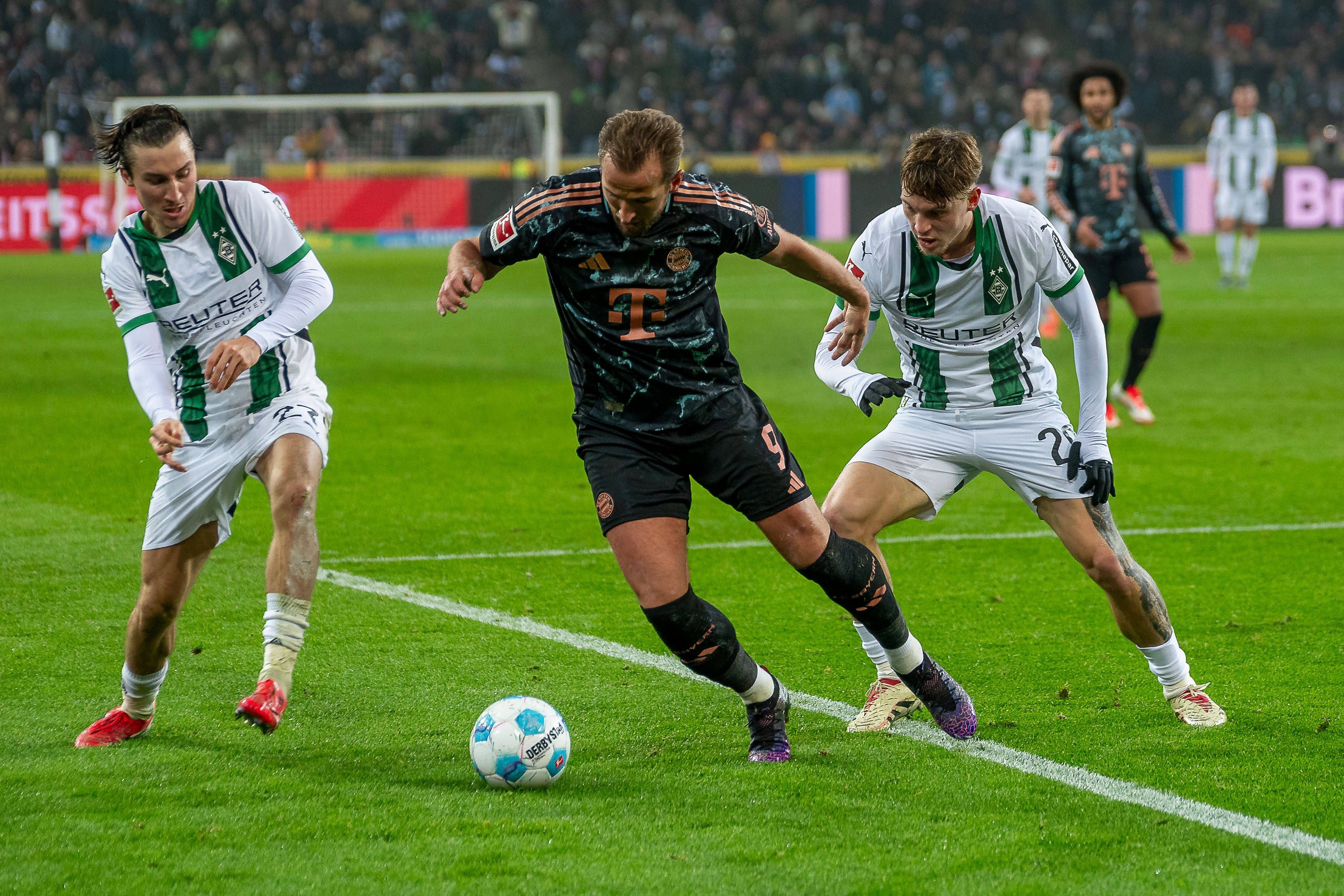 Rocco Reitz (l.) und Luca Netz (r.) im Zweikampf mit Harry Kane am 11. Januar 2025.