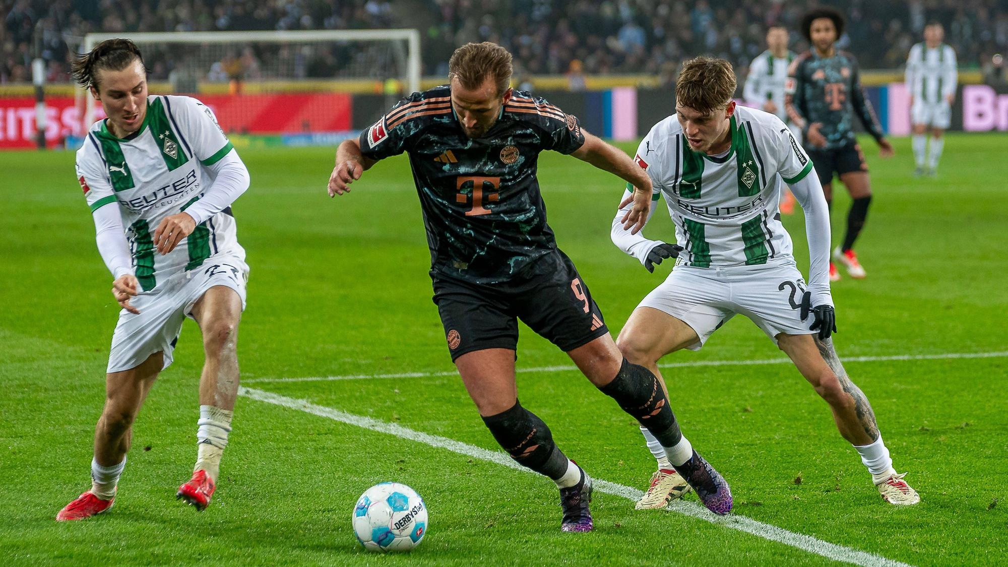 Rocco Reitz (l.) und Luca Netz (r.) im Zweikampf mit Harry Kane am 11. Januar 2025.